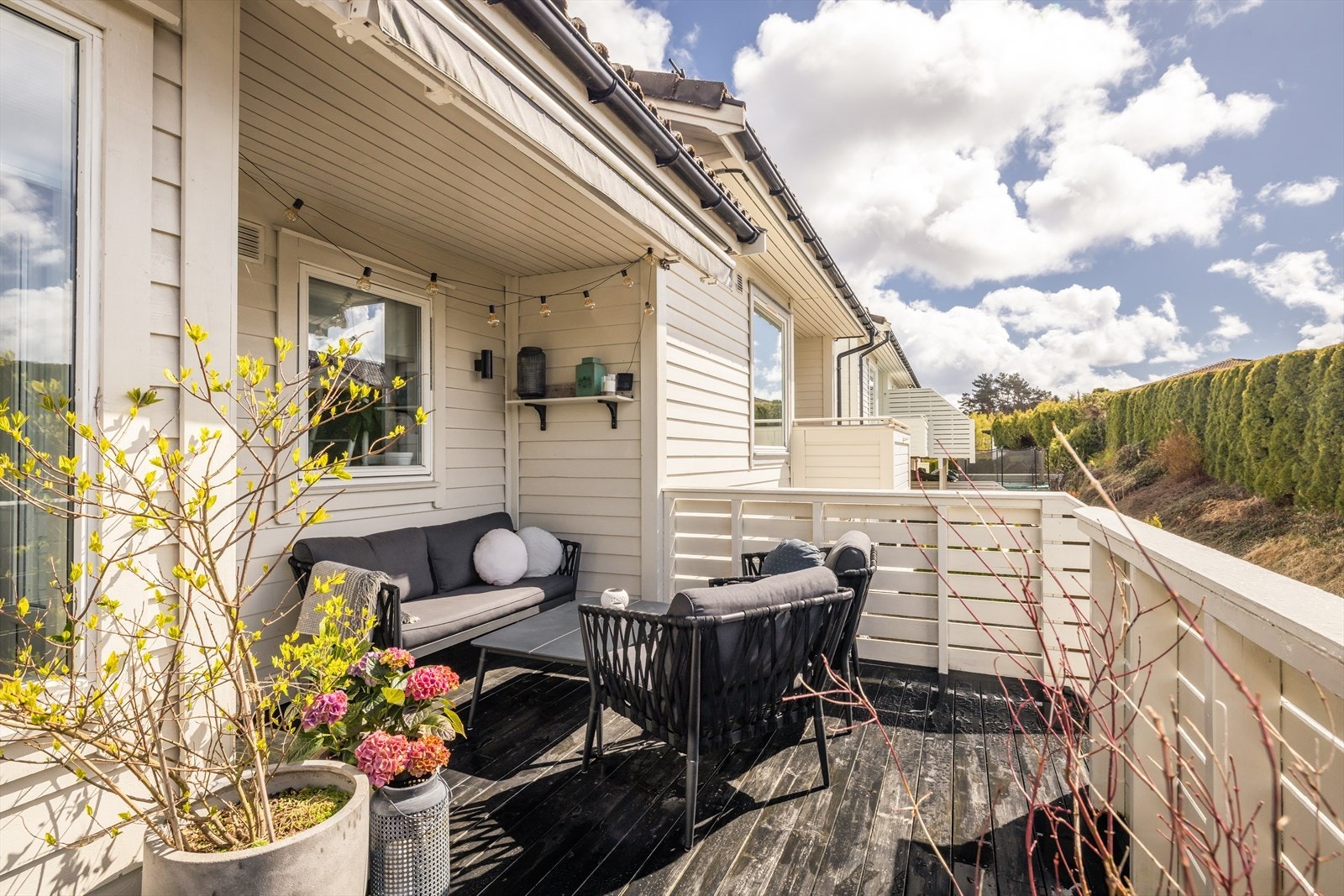 Romslig altan som er lett å dele inn i soner med plass til både grill og sofagruppe. Galleribilde
