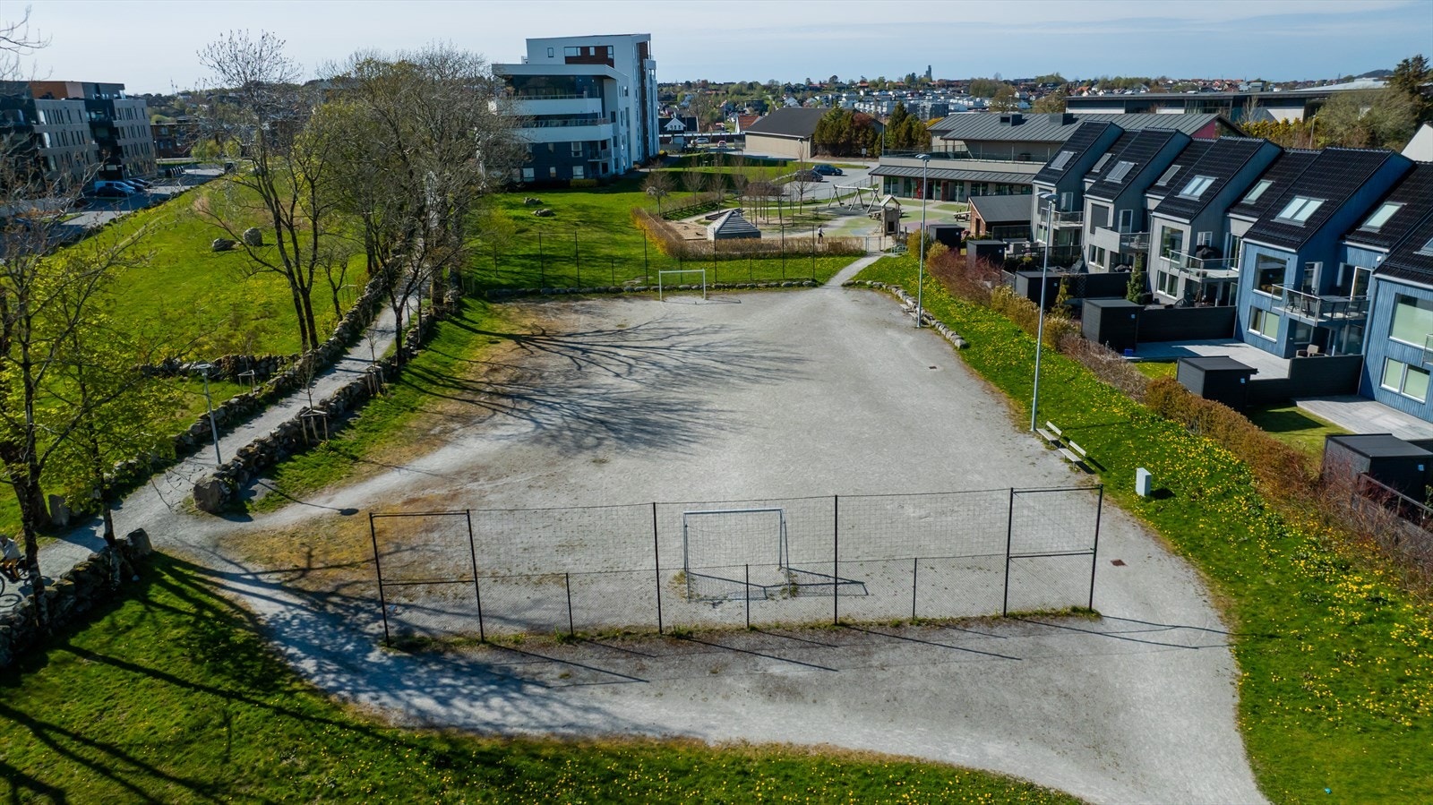 Rett utenfor døren ligger store grøntområder med balløkke og lekeplasser. Galleribilde
