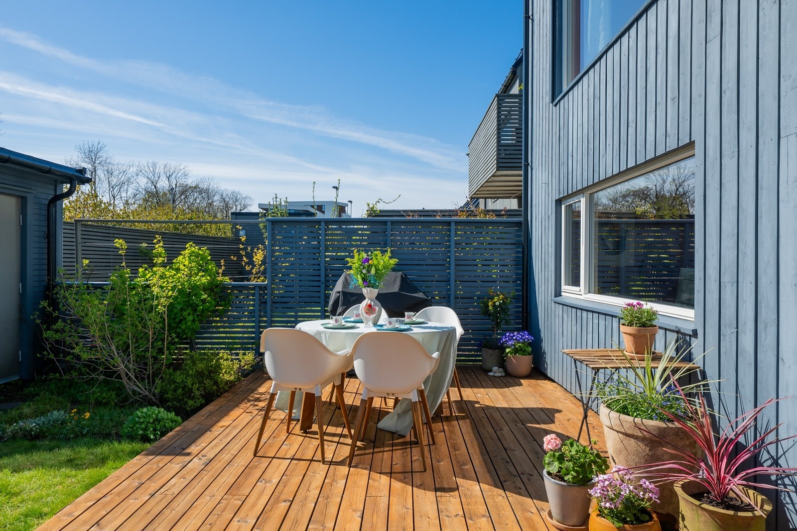 Terrassen er bygget med terrassebord og har rekkverk med liggende trespiler. Galleribilde