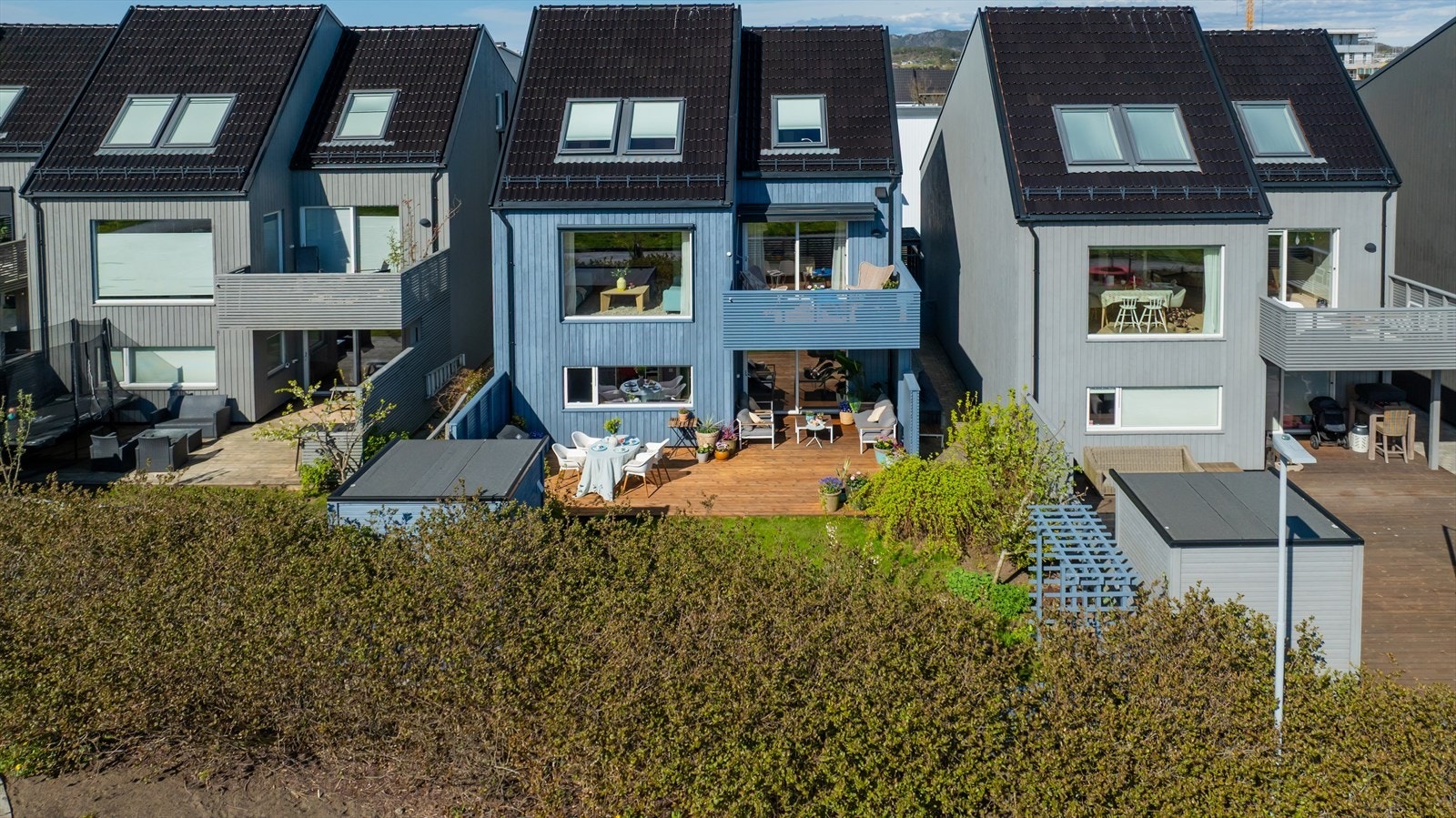 Boligens bakside med den store terrassen og hagen. Galleribilde