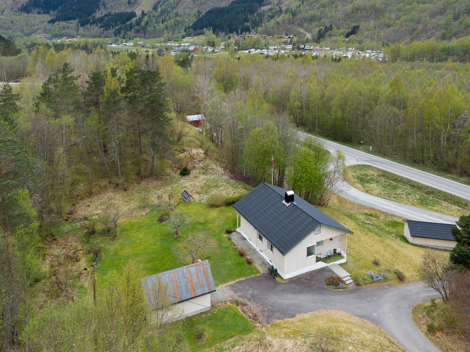 Eiendommen har en stor hage med plenarealer og en frittstående utebod. Galleribilde