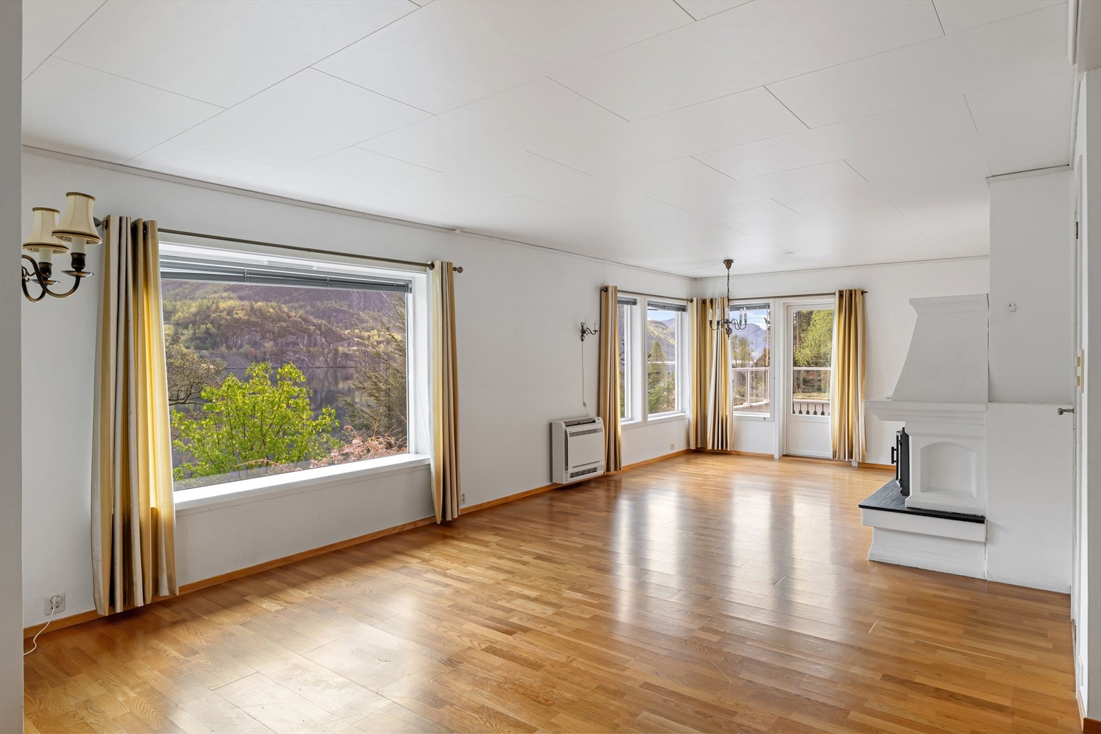 Store vindusflater i stuen rammer inn utsikten mot det omkringliggende landskapet. Galleribilde