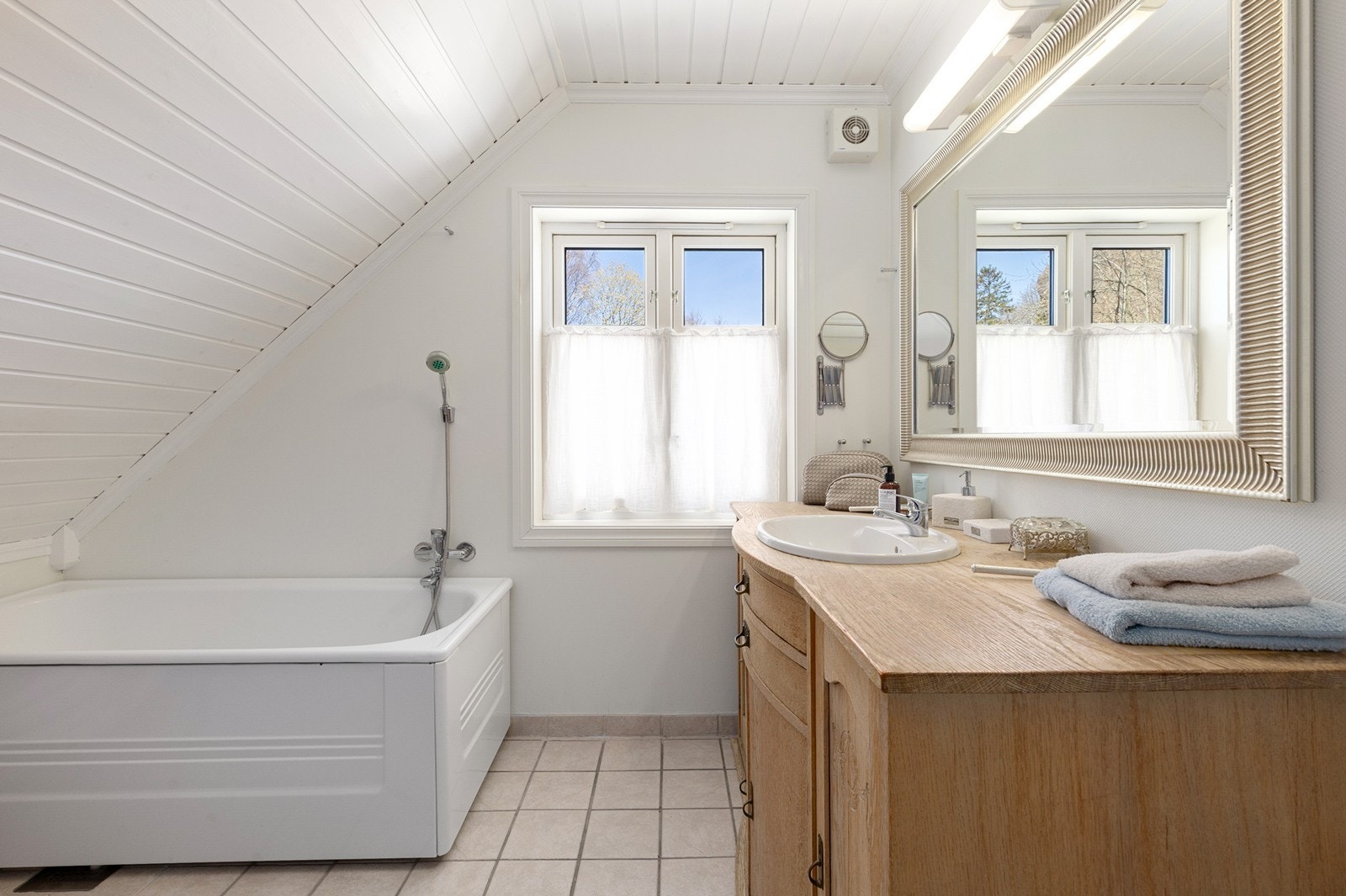 Romslig bad med servant og innredning og badekar. Galleribilde