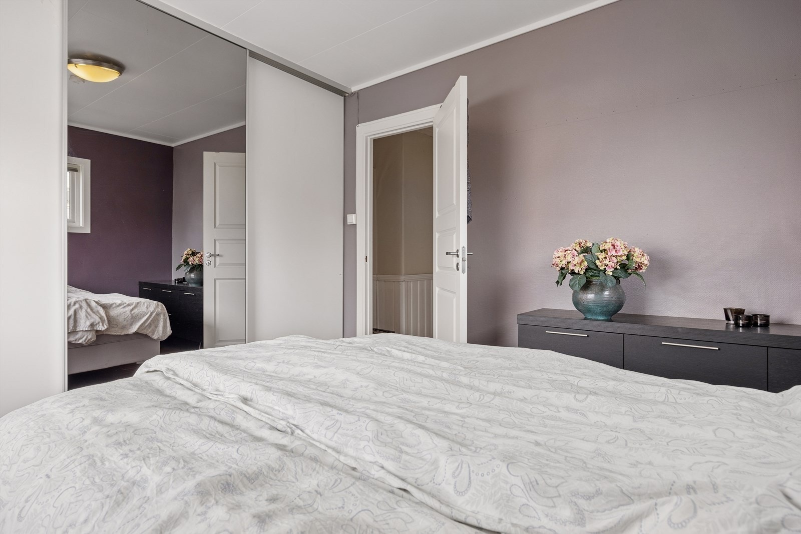En romslig skyvedørsgarderobe med speilfronter gir rikelig med oppbevaringsplass. Galleribilde