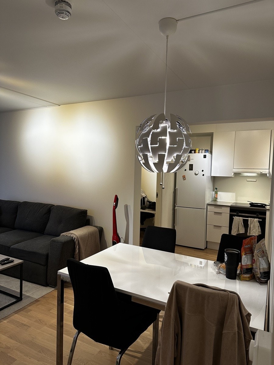 Spisestuedel: Spiseplass med hvitt bord og god plass til flere gjester, med åpen løsning mot stue og kjøkken. Galleribilde
