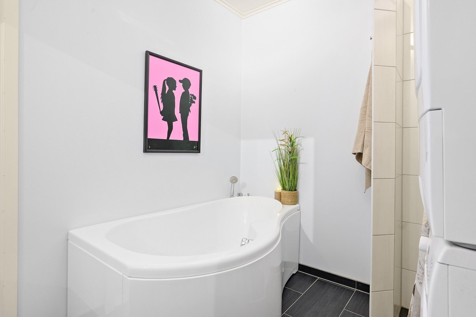 Badet er utstyrt med både badekar og dusjhjørne. Gulvet er flislagt og har elektriske varmekabler. Galleribilde