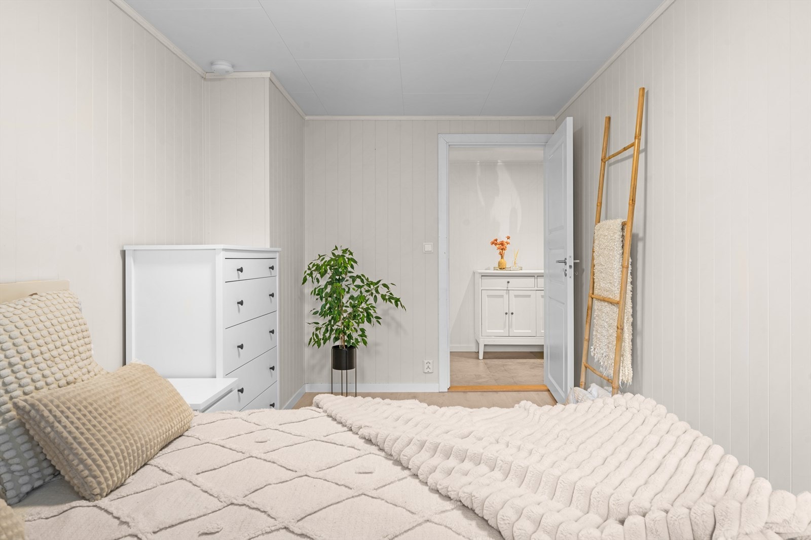 Rommet har en nøytral fargepalett og laminat på gulvet. Galleribilde