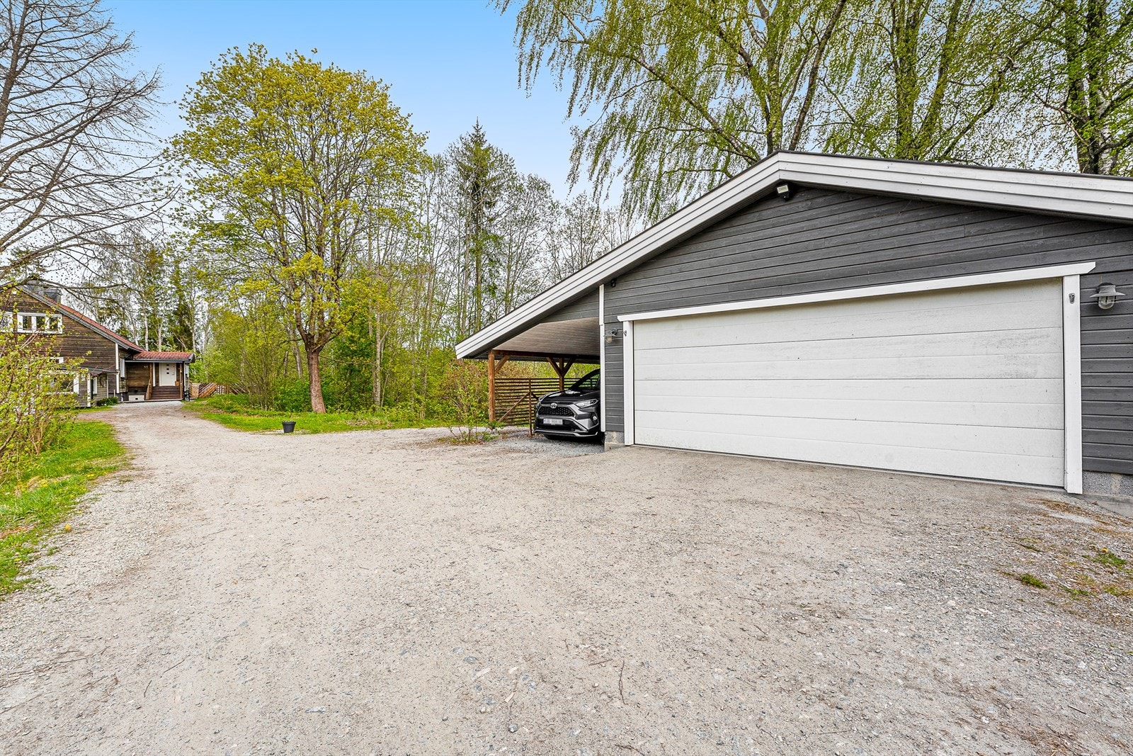 Dobbelgarasje med carport. Denne står delvis på naboens tomt. Galleribilde