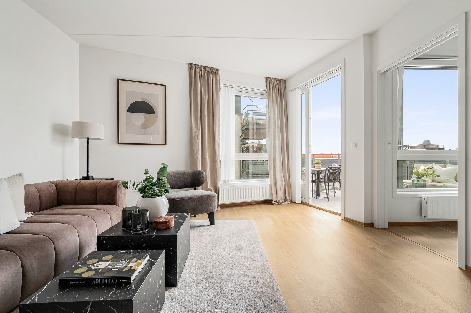 Lys og innbydende stue med store vindusflater som slipper inn rikelig med naturlig lys og skaper en luftig romfølelse Galleribilde