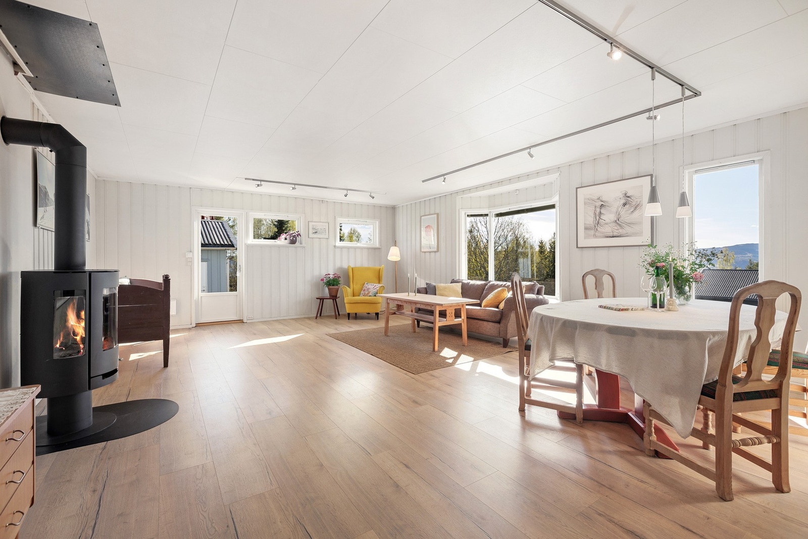 Stuen er lys og romslig med store vindusflater som slipper inn rikelig med naturlig lys og utsikten kan nytes fra sofakroken. Galleribilde