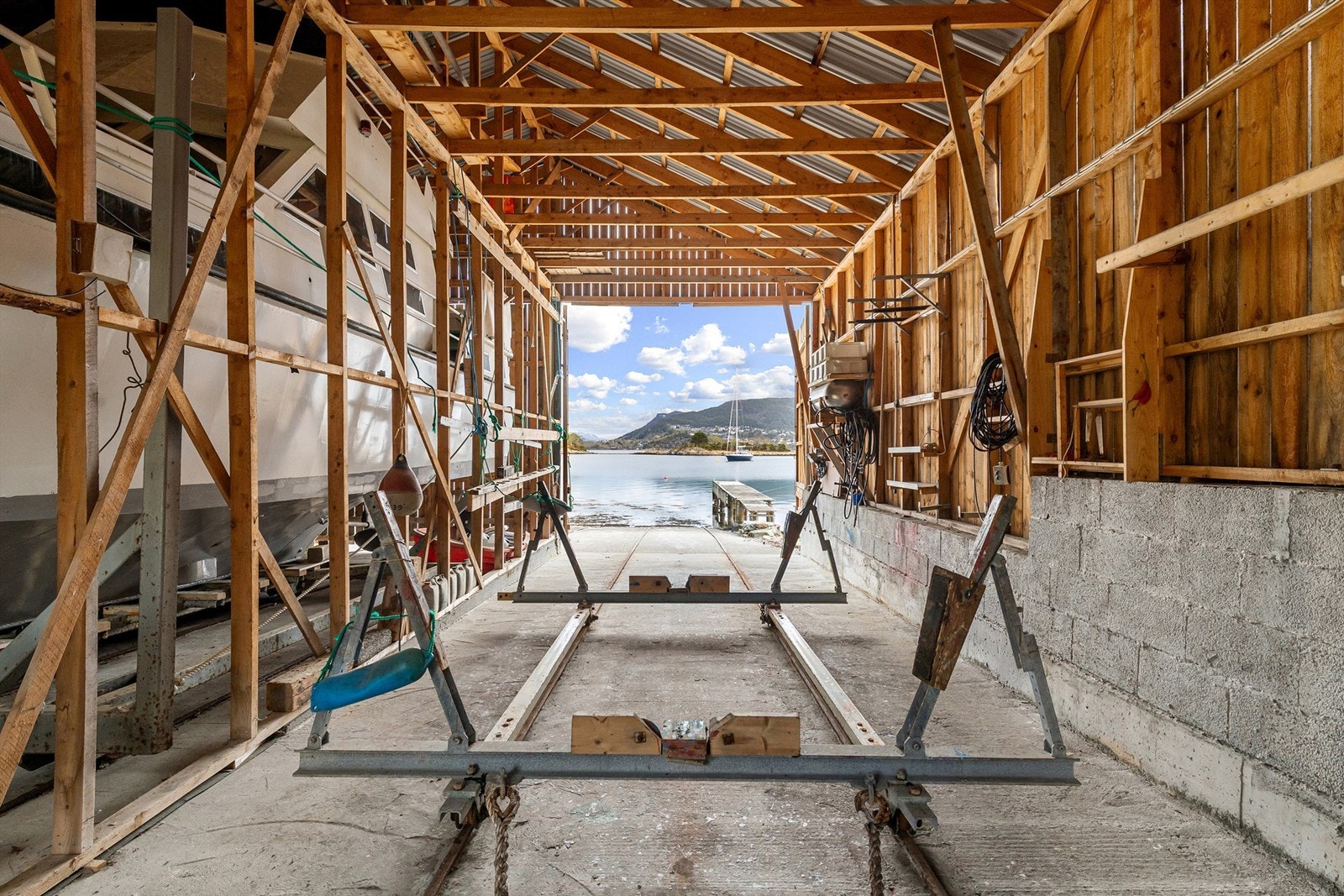 Innvendig er naustet utstyrt med elektriske vinsjer og skinner for enkel sjøsetting. Den gode takhøyden på opptil 4,95 meter gir plass til selv større båter. Foto: Stian Wiik Galleribilde