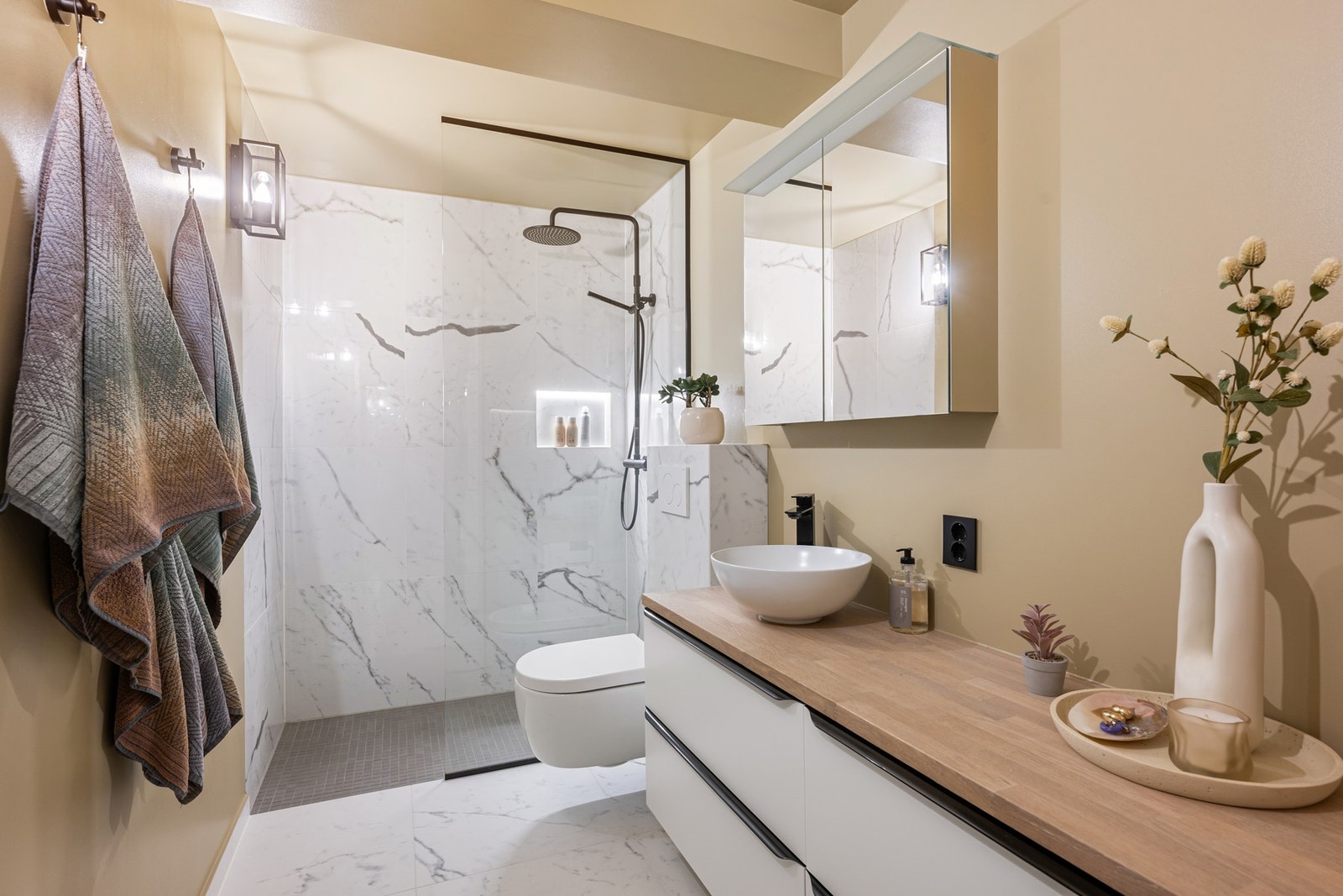 Badet har fått TG1 i tilstandsrapporten og fremstår som både stilrent og funksjonelt, med dusjhjørne, glassvegg, regnfallsdusj og servantbolle på benk. Galleribilde
