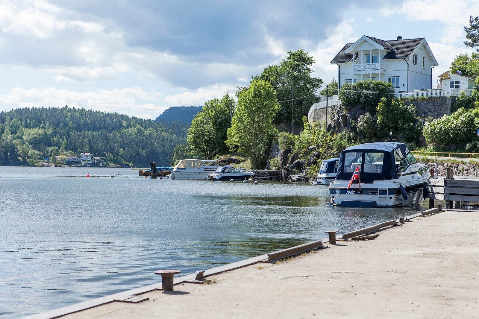 Bildet er fra Løveid. Et område nært Løveid sluser og den aktuelle tomten. Et lite idyllisk småsted med brygger og en liten badestrand. Galleribilde