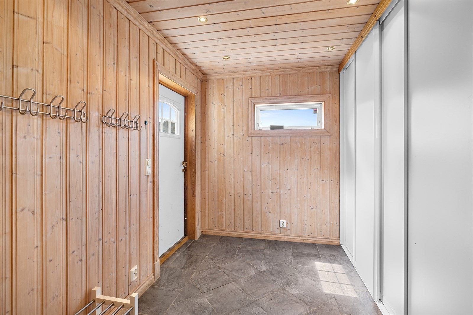 Praktisk entré med flislagt gulv, downlightsbelysning og mye skapplass. Galleribilde