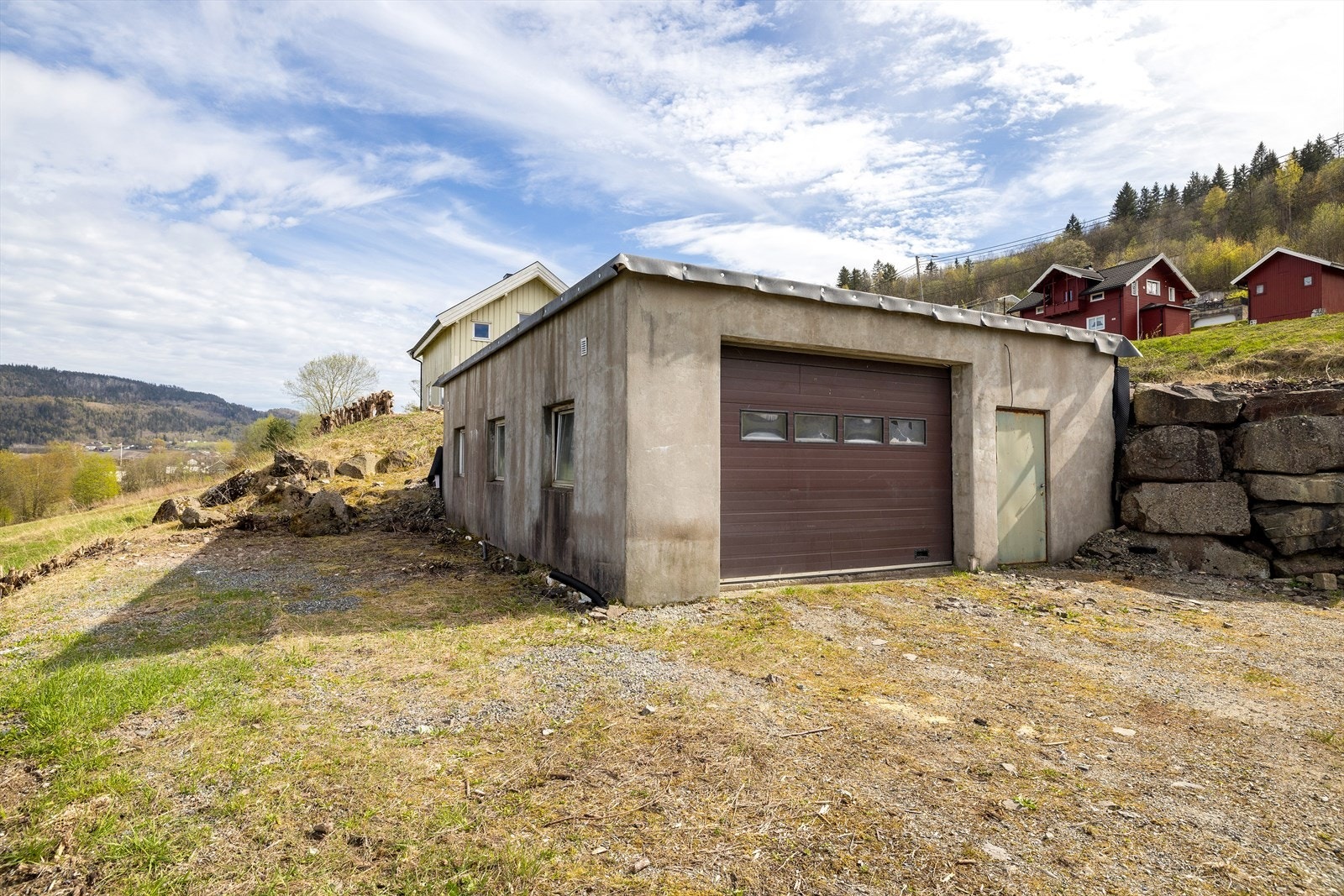 Nederst på tomten er det stor garasje/verkstedbygning på 78 kvm med flere bruksmuligheter. Garasjen har port og gangdør. Galleribilde