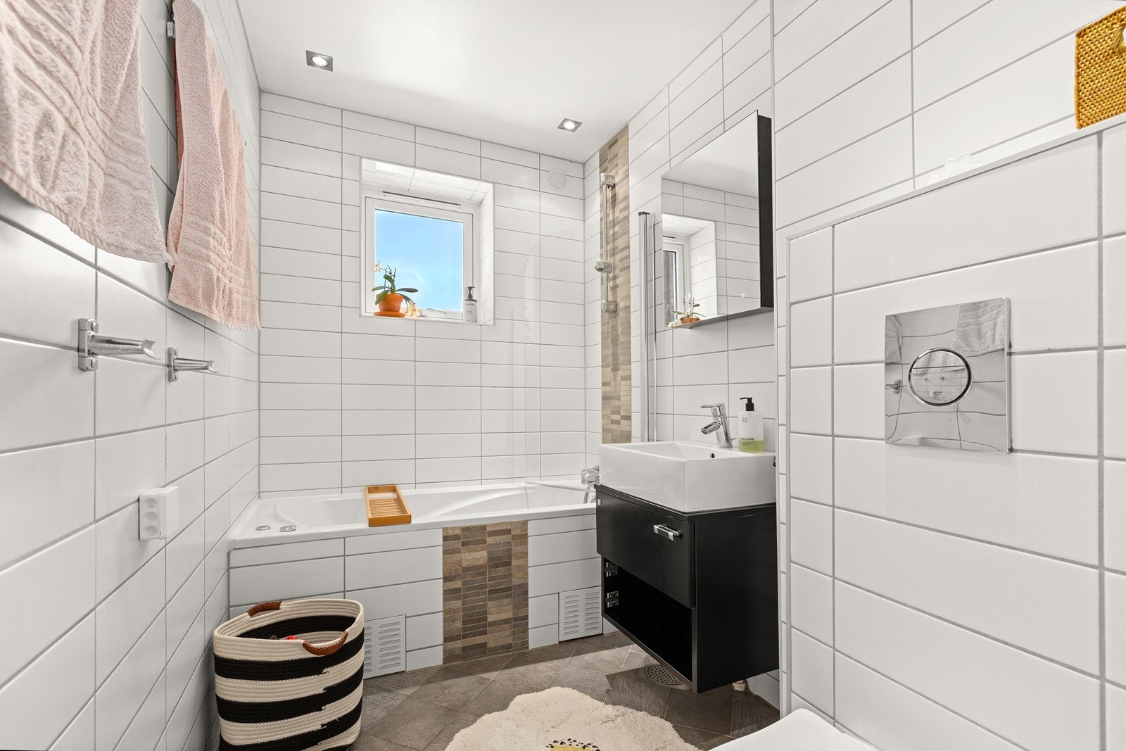 Badet er flislagt og opplyses å være fra 2009. Rommet har servantinnredning, vegghengt toalett, badekar og varmekabler i gulv, og fremstår som et funksjonelt baderom for daglig bruk. Galleribilde
