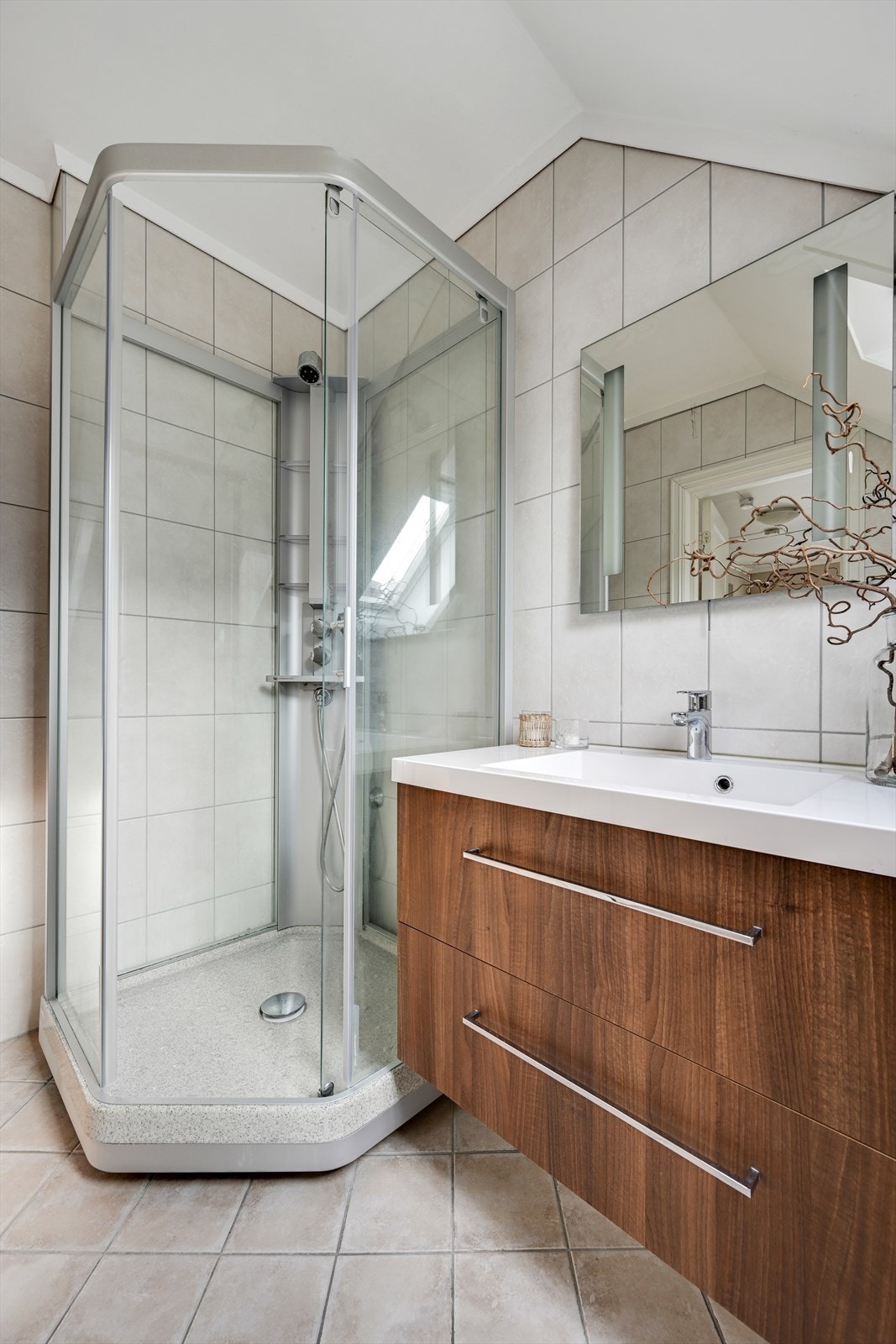 Badet er innredet med dusjkabinett og en moderne servant i baderomsinnredning. Galleribilde