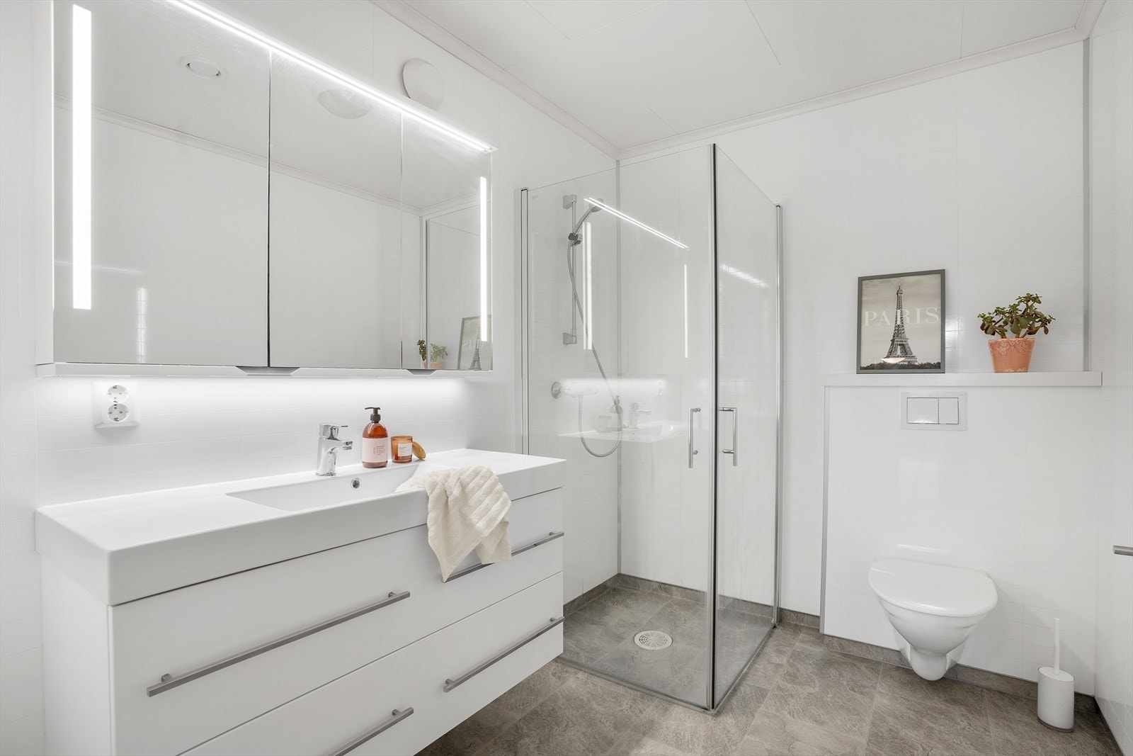 Badet i underetasjen har dusjhjørne med glassvegger, vegghengt toalett og varmekabler i gulvet. Galleribilde