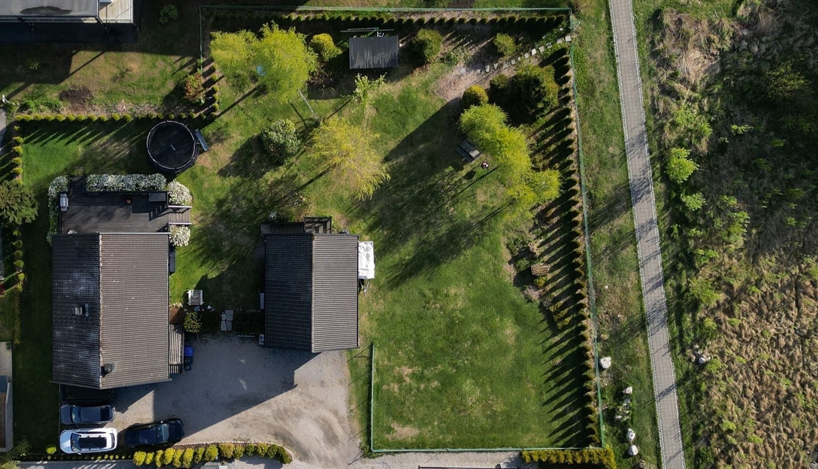 Eiendommen er stor og flat. Huset og innkjørselen er plassert mot nord-øst på eiendommen. Dette gjør at hele resten av tomtearealet har store anvendelige arealer og står med gode solforhold hele dagen. Bildet er tatt på ettermiddagen. Galleribilde