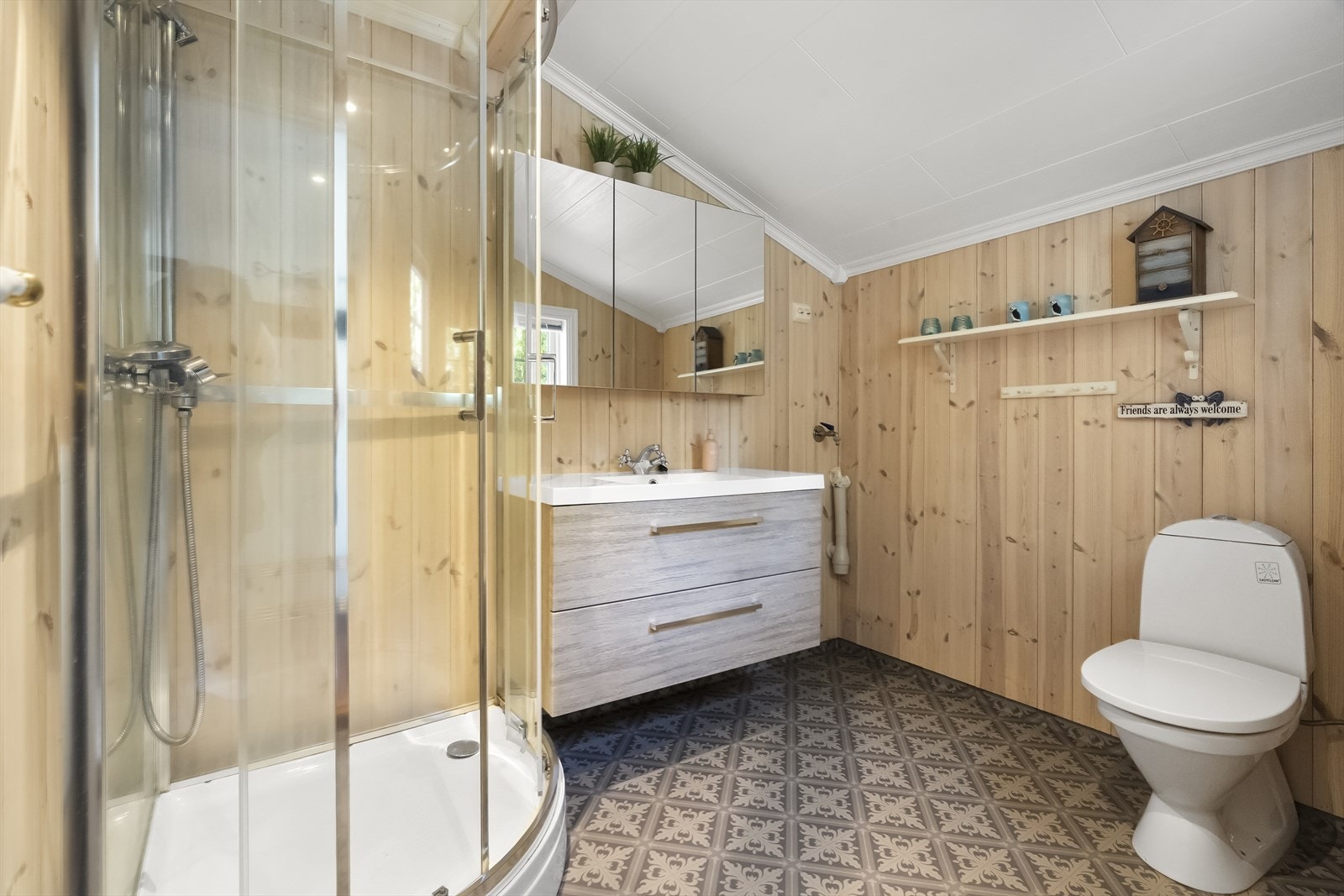 Badet er utstyrt med dusjkabinett, toalett og servantinnreiing med skuffer Galleribilde