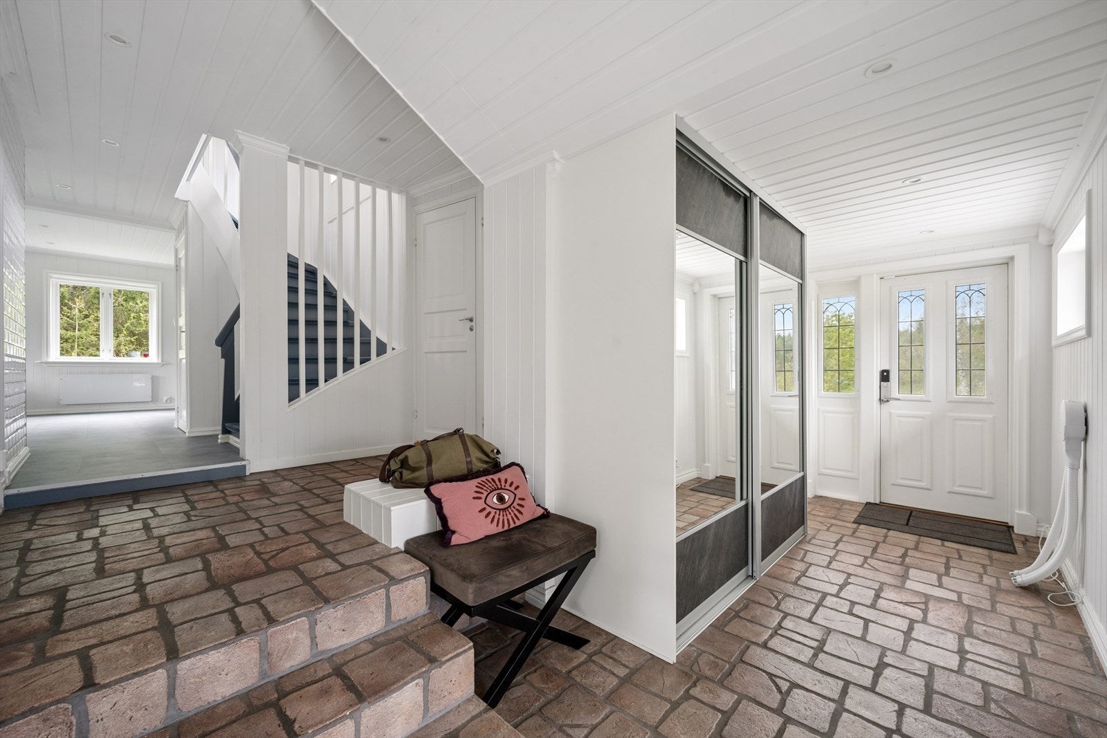 Romslig, flislagt entré med god plass til å sette fra seg yttertøy og sko. Galleribilde