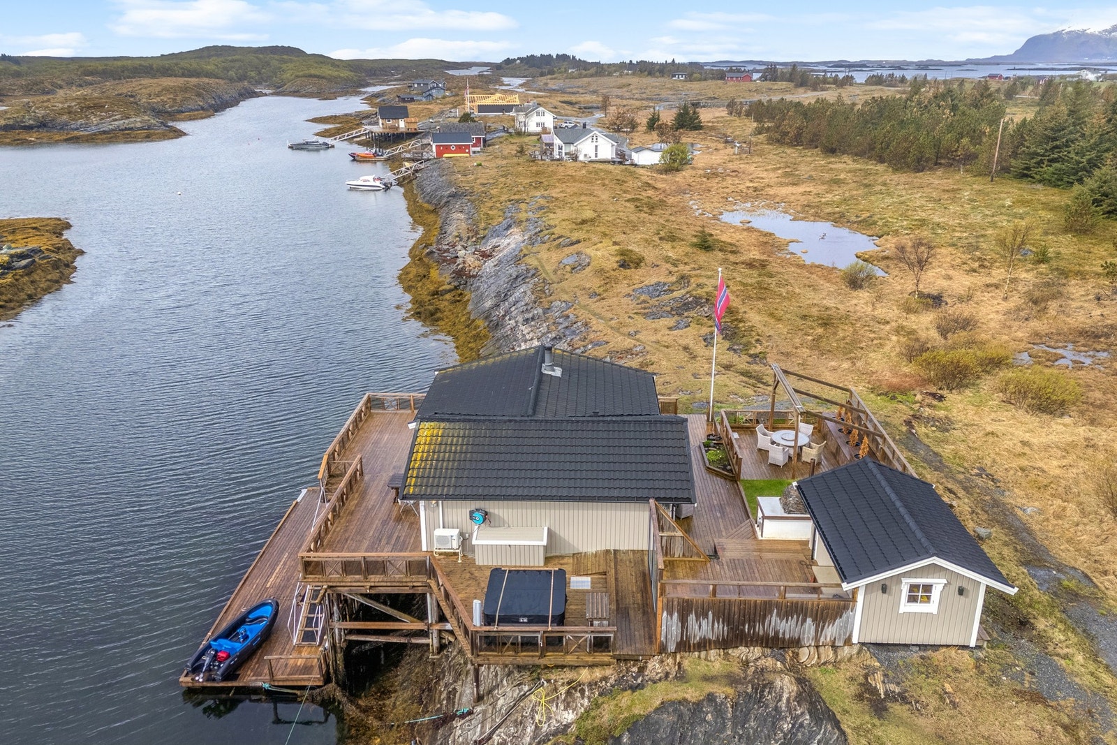 De store uteområdene på totalt 215 m² omkranser hytta og inkluderer en ny jacuzzi fra 2024, flere soner for uteliv og direkte tilgang til havet. Galleribilde