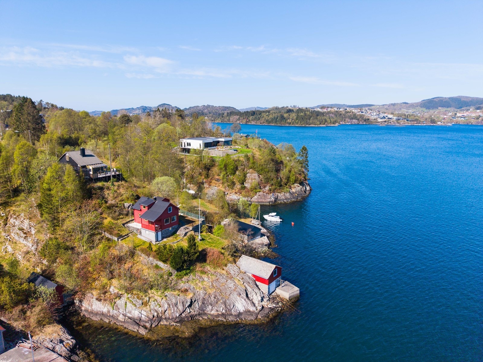 Eiendommen inkluderer et naust over to etasjer, perfekt for et aktivt båt- og sjøliv. Herfra har du utsikt mot både Nordhordlandsbroen og Haggelsundbroen, utover i fjorden. Galleribilde