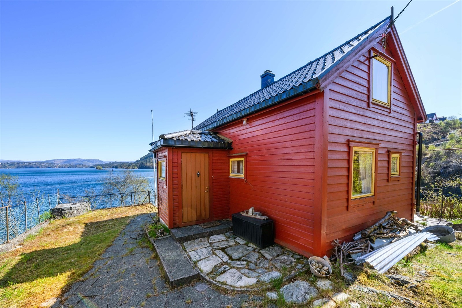 Adkomstparti med hellelagt sti og malt hovedytterdør. Galleribilde