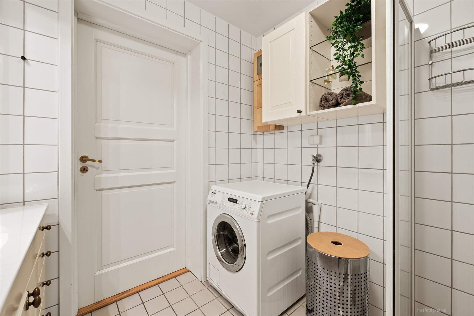 Badet har dusjhjørne med skyvedører og opplegg for vaskemaskin. Galleribilde