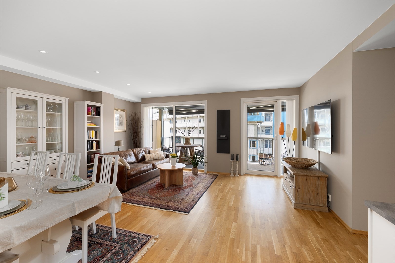 Oppholdsrommet har lyse overflater, innfelte downlights i himling og store vindusflater Galleribilde