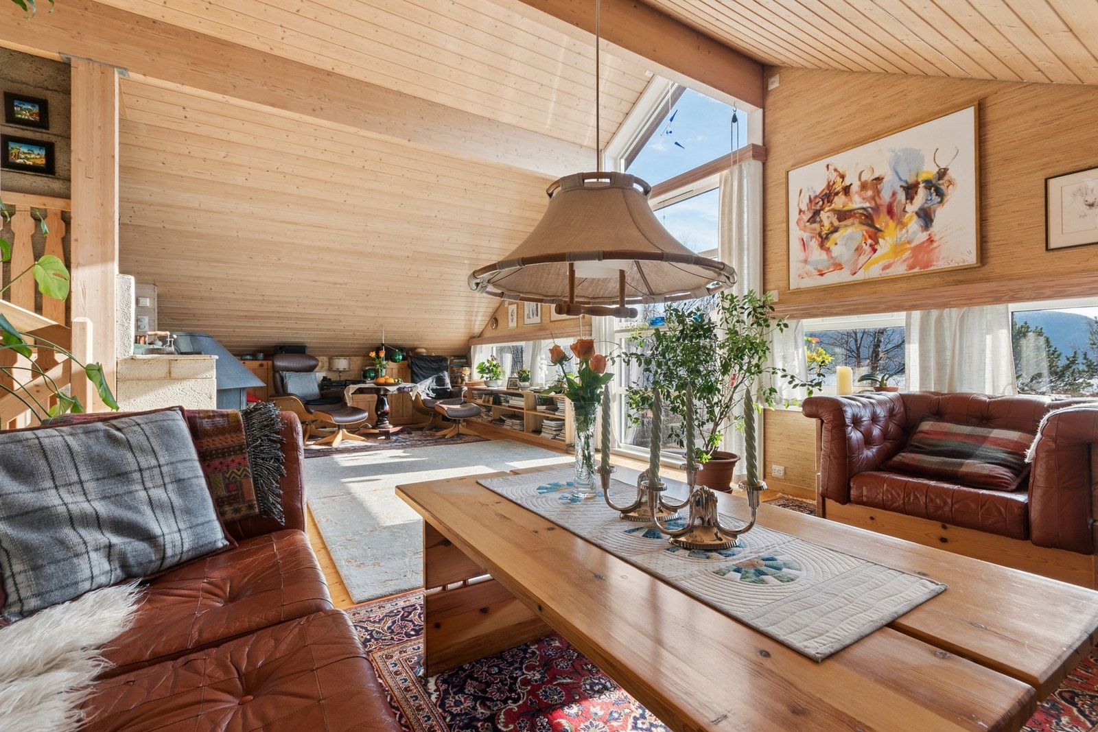 Stuen er romslig og har flere soner, med god plass til både sofagruppe og en egen lesekrok ved peisen. Galleribilde