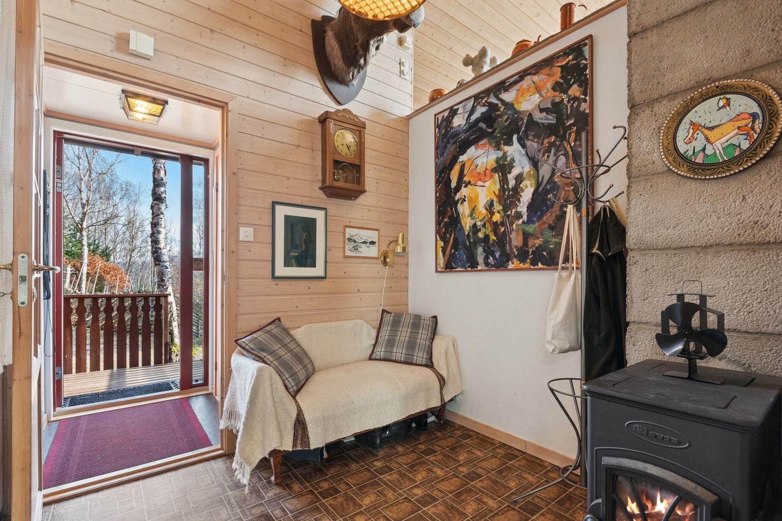 Innbydende entré med vedovn som gir en varm velkomst. Galleribilde