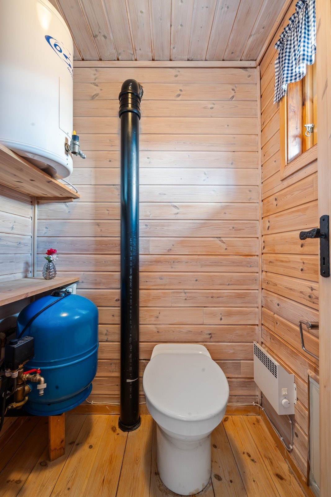 Fra badet er dør inn til wc i eget rom. Her er trykktanken for borehullet, varmtvannsbereder og biodo med fire kammer. Galleribilde