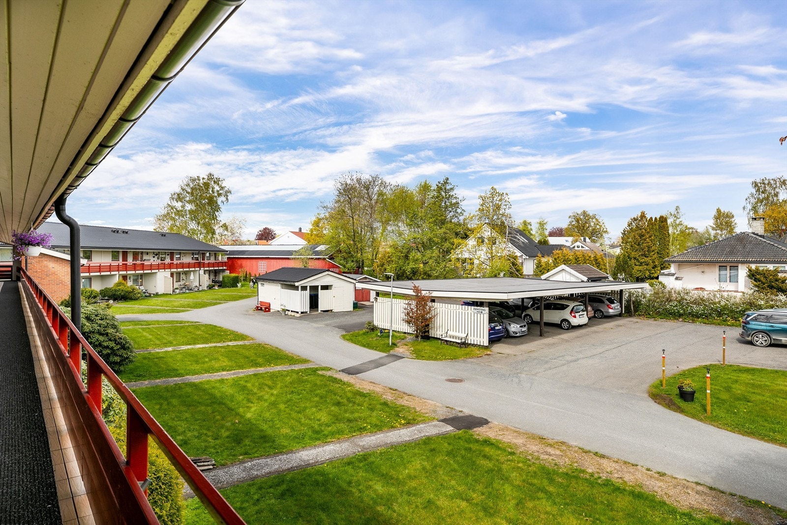 Utsyn fra svalgangen til fellesarealet der leiligheten disponerer biloppstillingsplass. Ved plassen er det montert ladepunkt som medfølger. Galleribilde