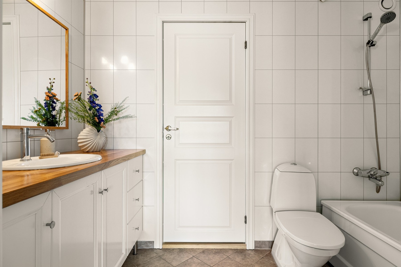 Badet er innredet med toalett, badekar med dusj og baderomsinnredning med speil og belysning. Galleribilde