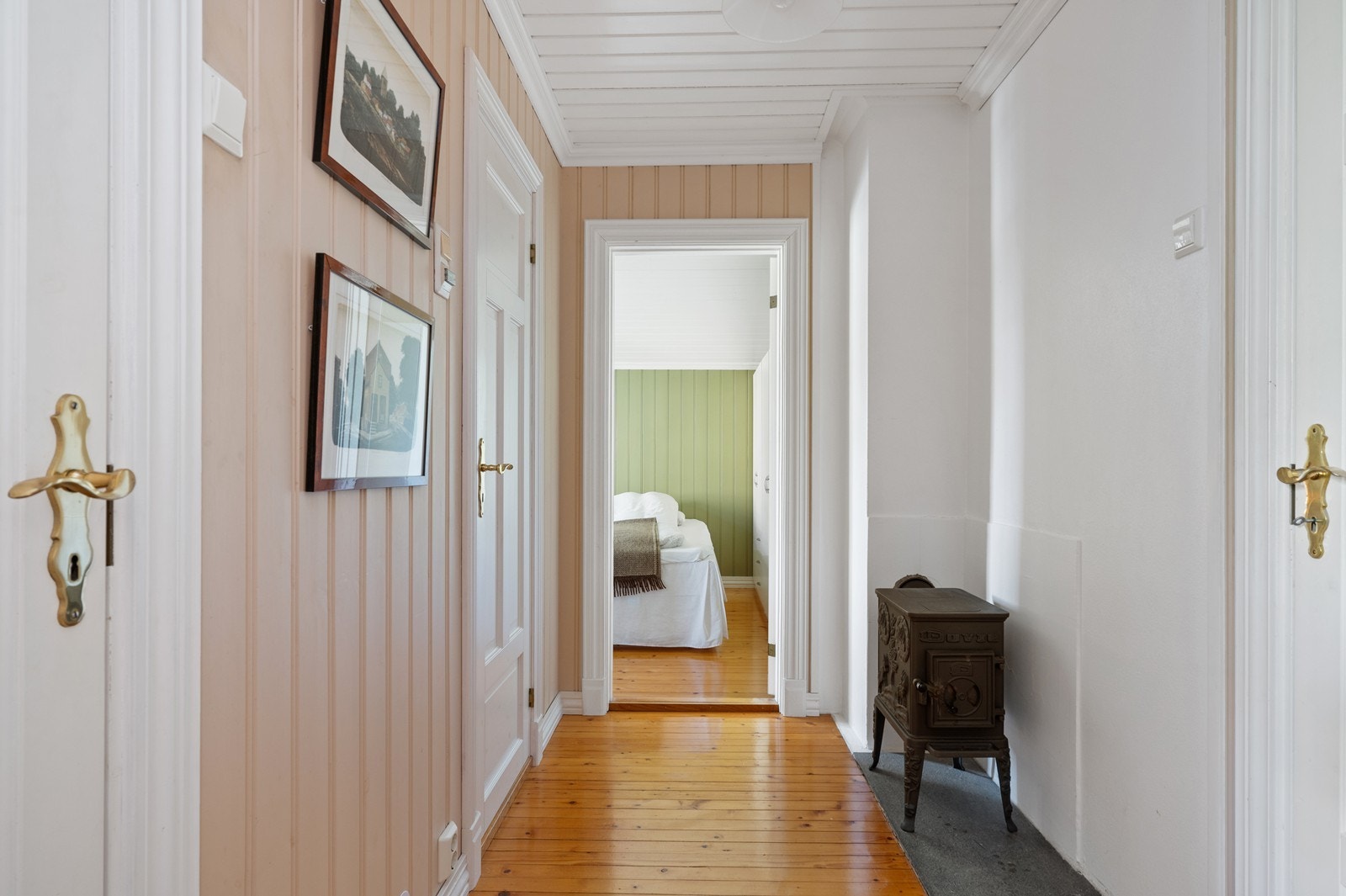 Gang i 1. etasje med adkomst til soverom, bad og toalettrom. Også her er det en nostalgisk vedovn. Galleribilde