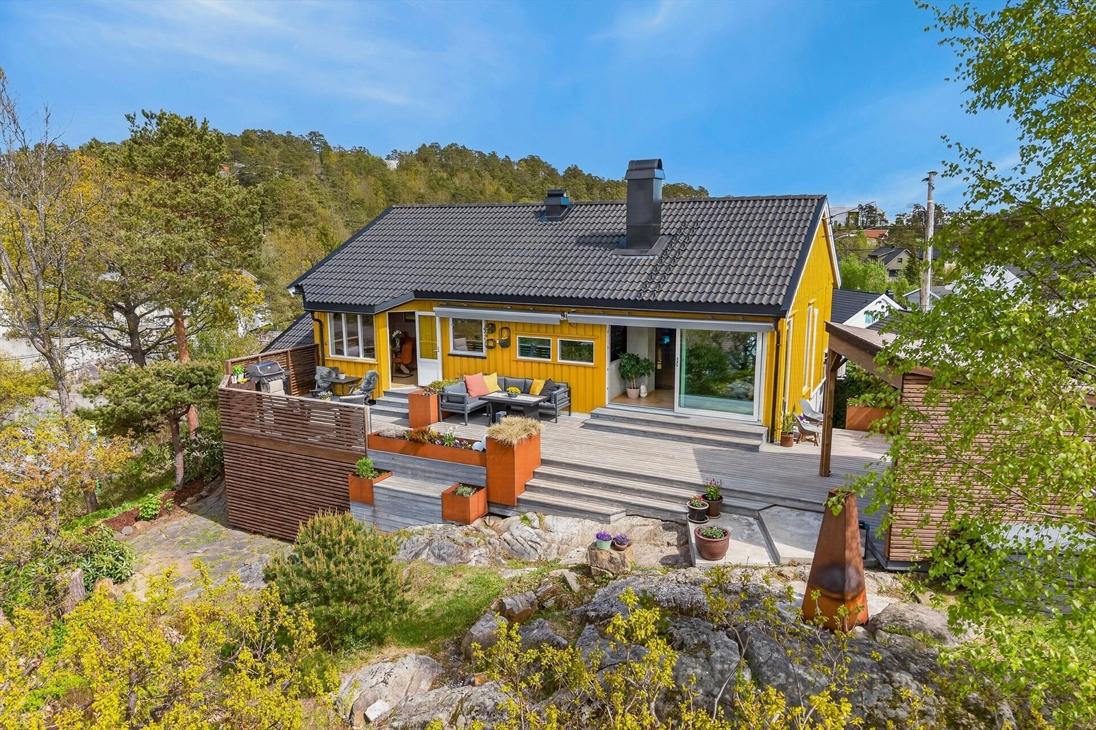 Den store terrassen i behandlet tre er delt inn i flere soner for soling, grilling og sosialt samvær. Galleribilde