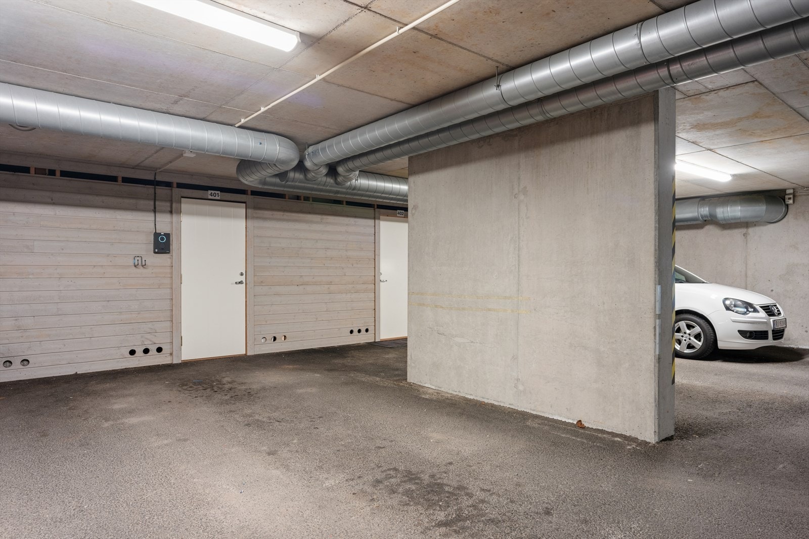 Fast parkeringsplass med elbil-lader og tilhørende bod. Galleribilde