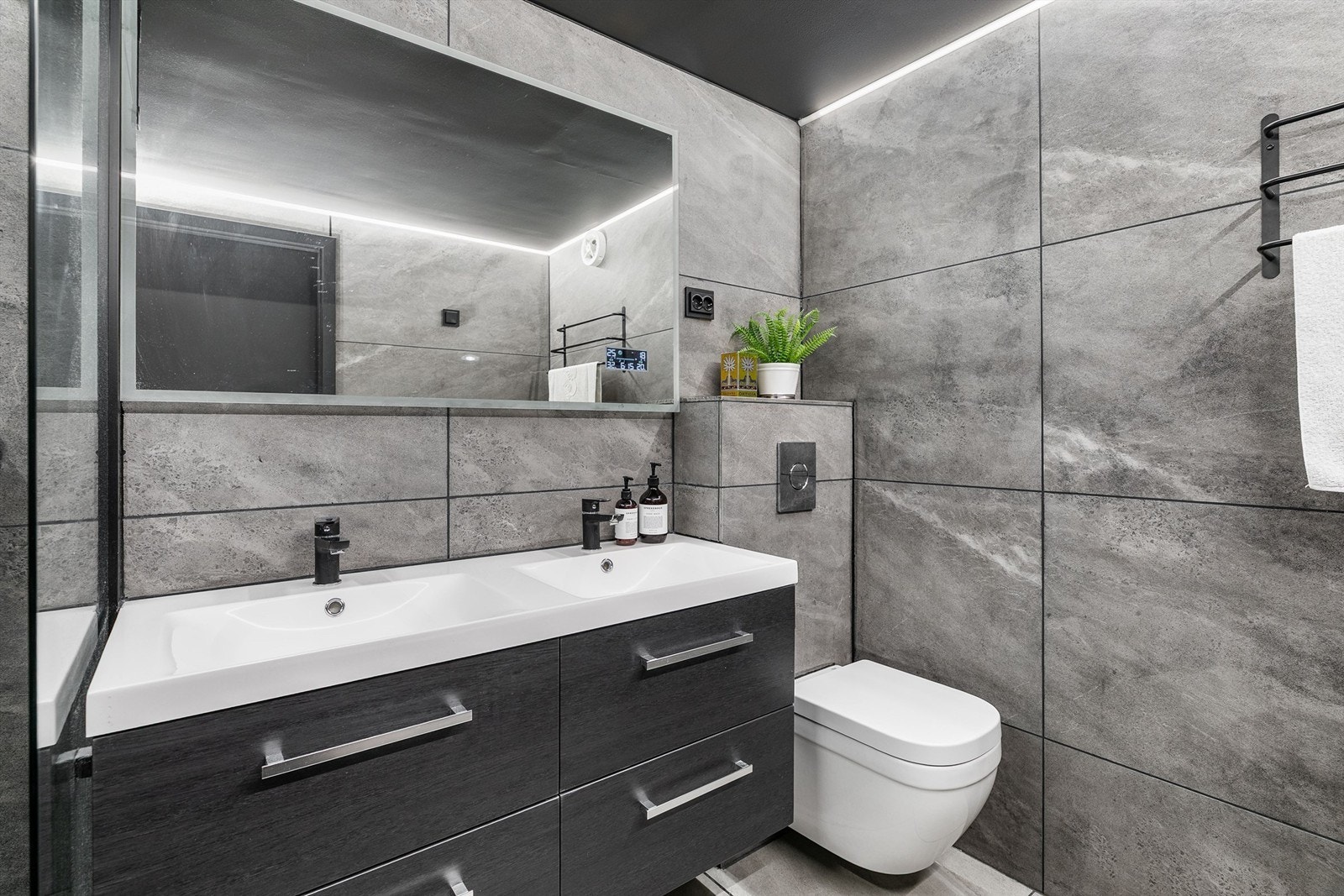 Badet ble renovert i 2020 og er like gjennomtenkt som resten av leiligheten. Dobbel servant gjør det enkelt for to personer å benytte badet samtidig. Galleribilde