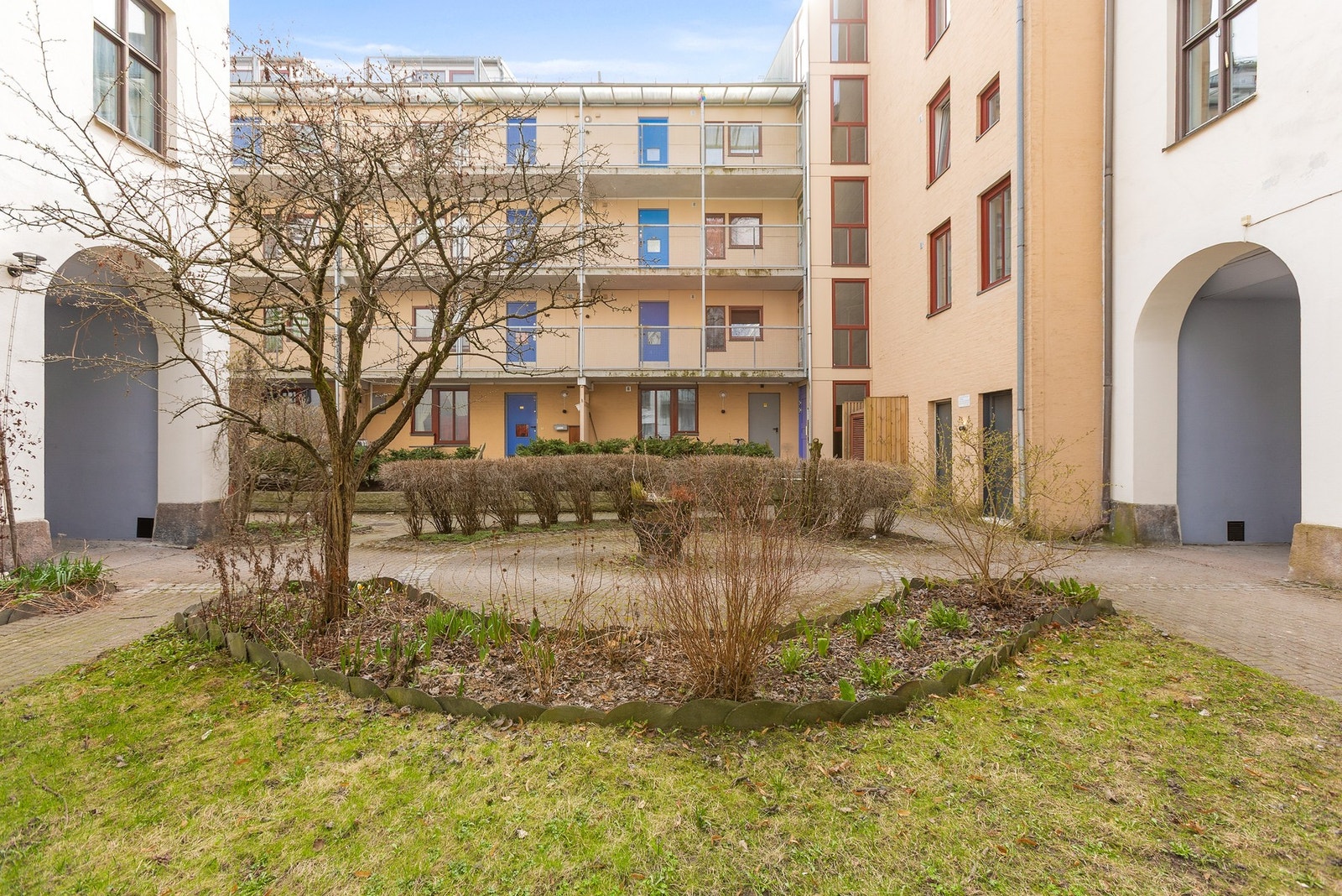 Bakgården er pent opparbeidet med gressplen, sittebenker, gangvei og beplantning. Galleribilde