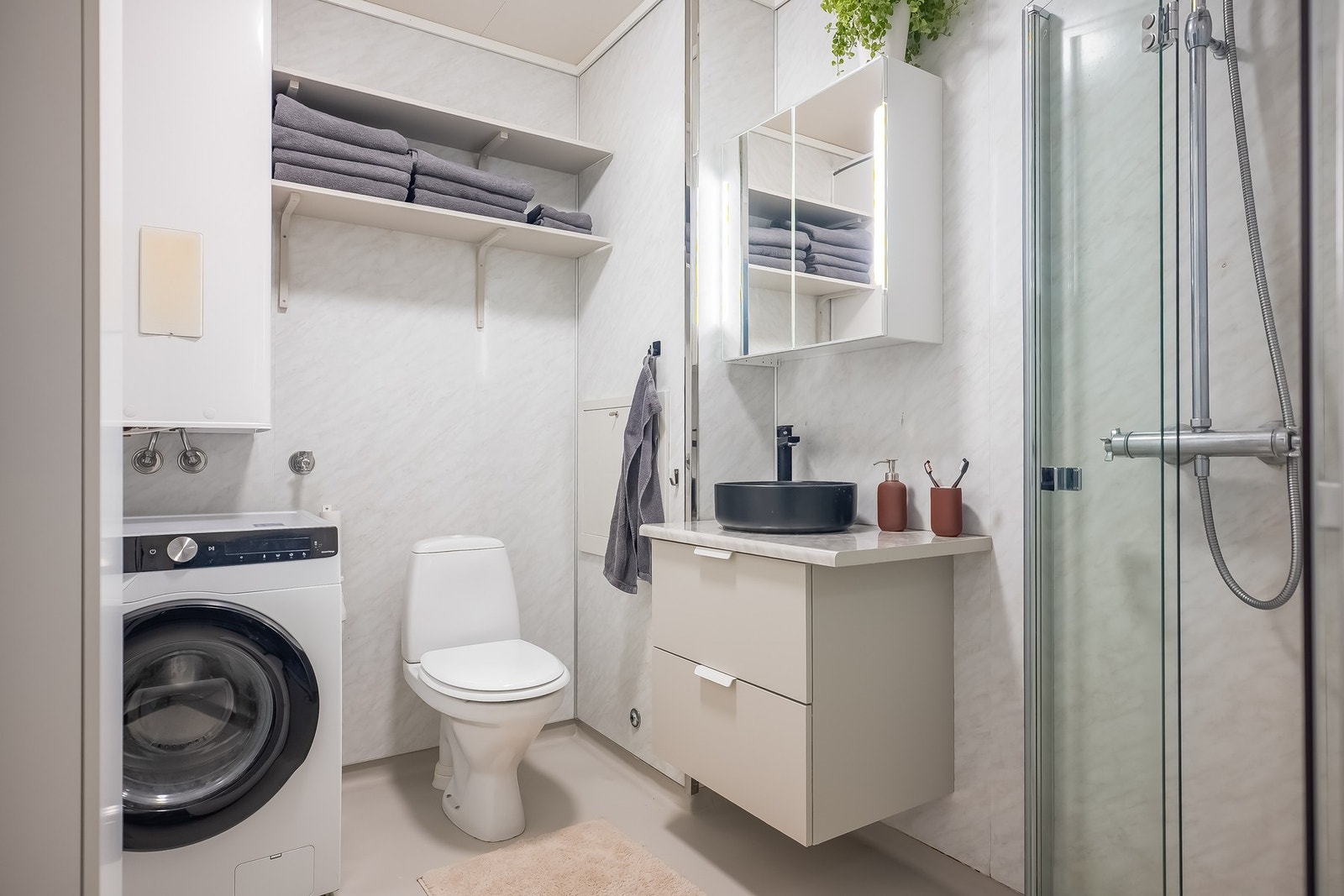 Badet er praktisk utnyttet med wc, dusj, servantskap og opplegg for vaskemaskin. Galleribilde