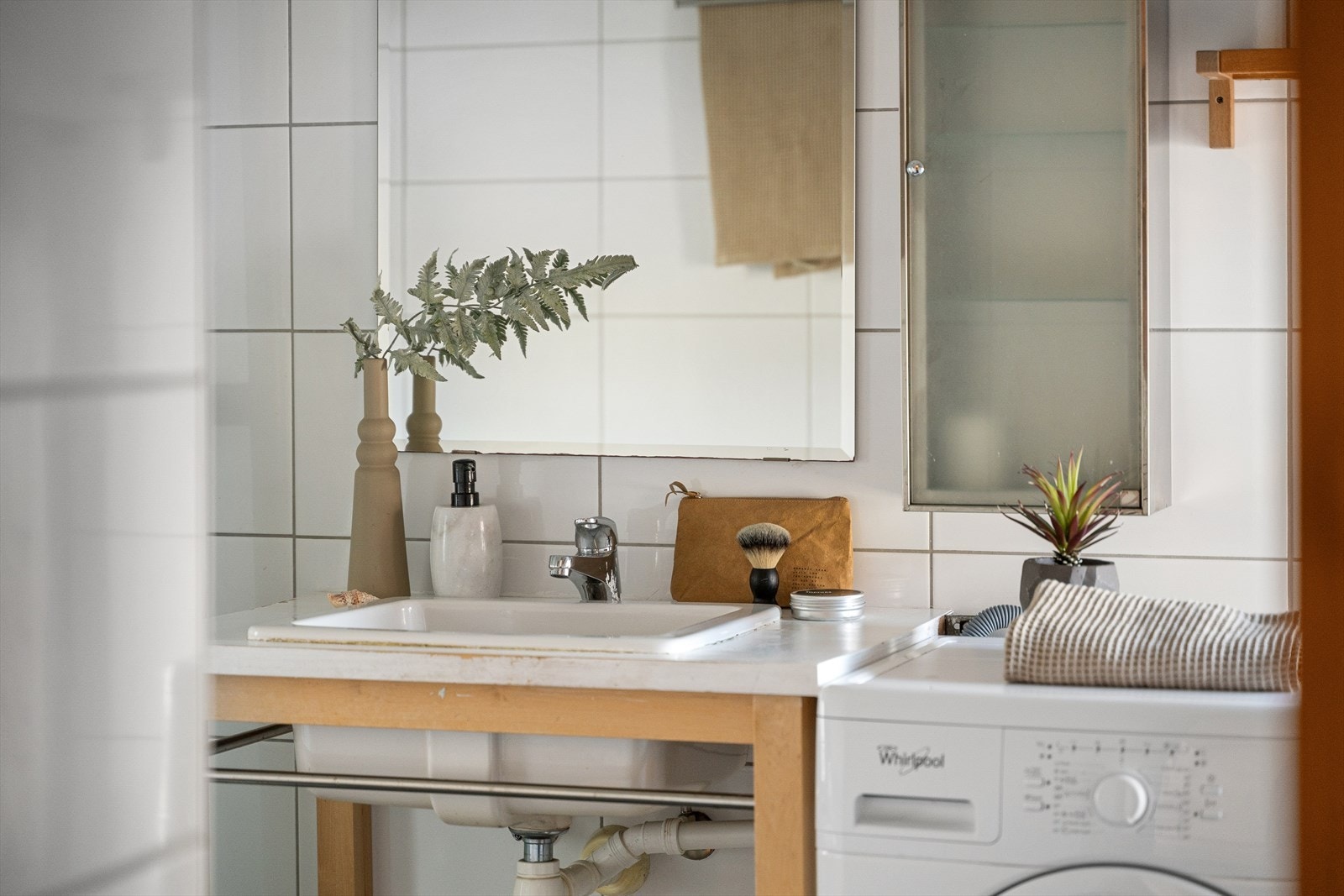 Badet har innredning med nedfelt servant og opplegg for vaskemaskin. Galleribilde