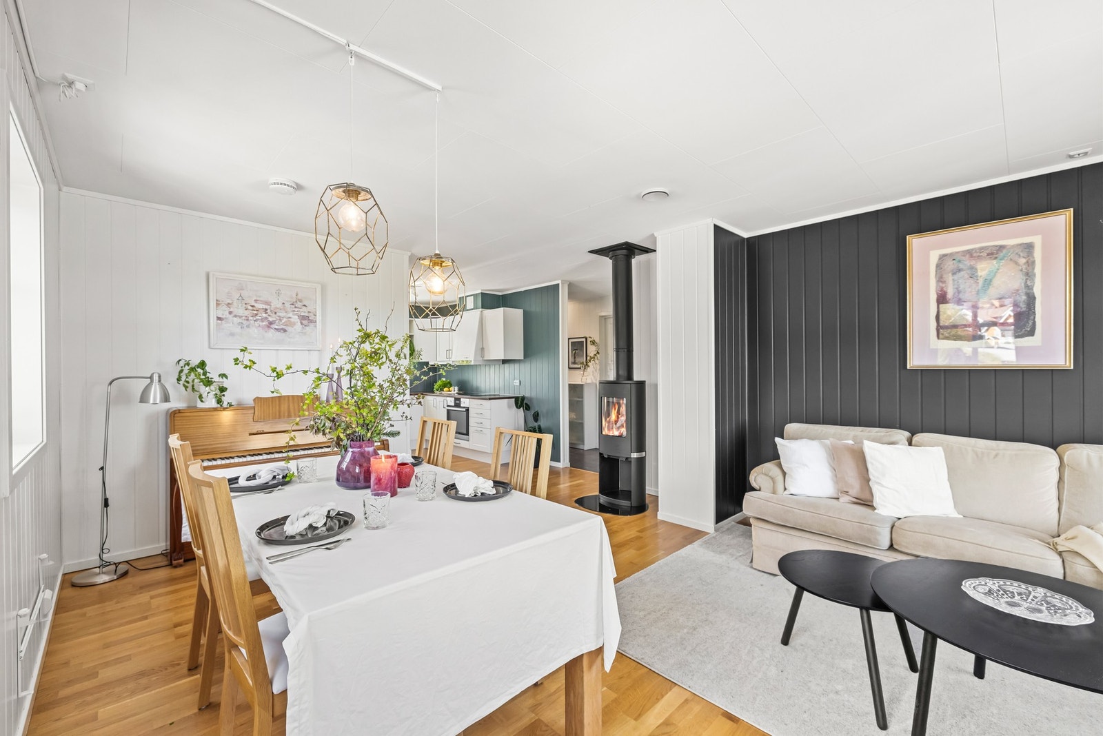 Veggene i stuen er hvitmalte og har en blå kontrastvegg bak sofaen. Galleribilde