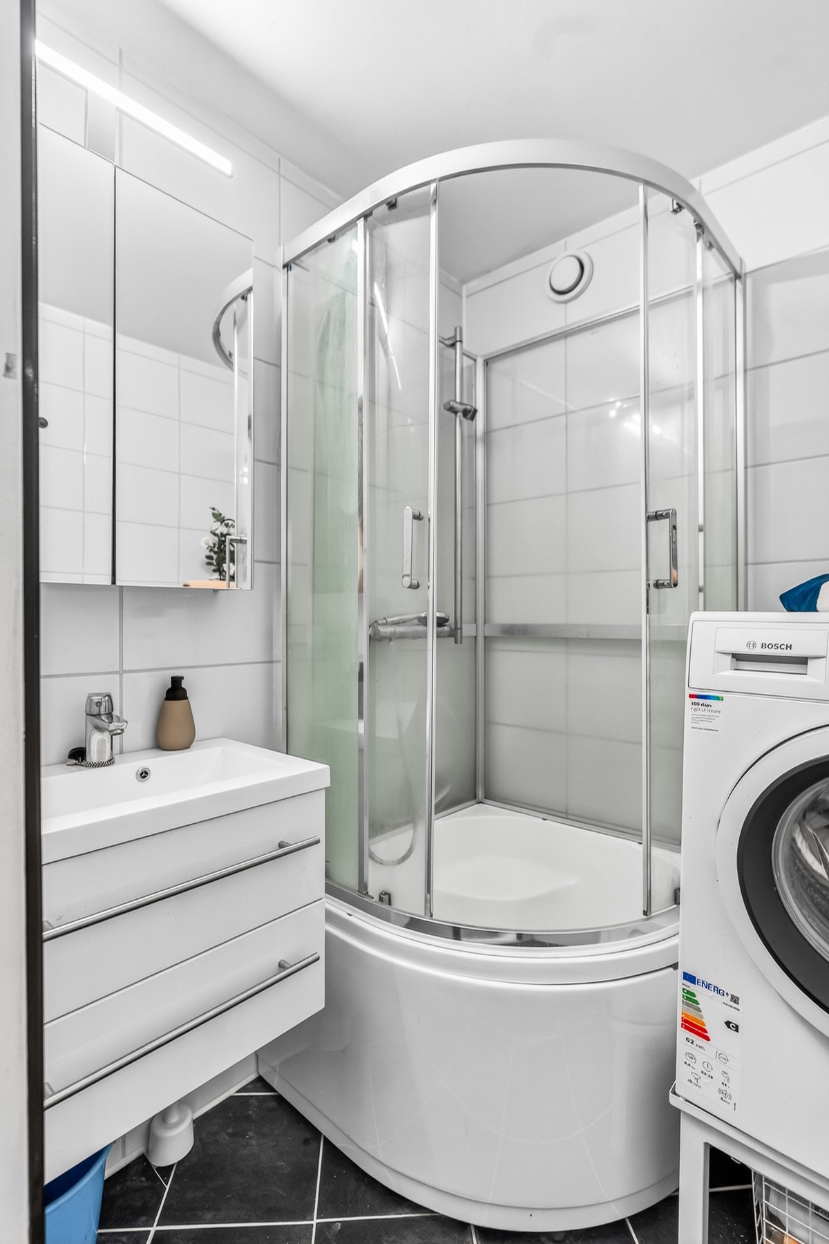Badet er innredet med dusjkabinett, servant med innredning, speilskap og det er opplegg for vaskemaskin. Galleribilde