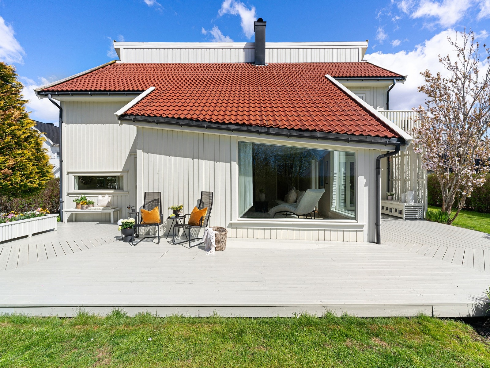 Tomten er pent opparbeidet med terrasse, plen og beplantning. Galleribilde