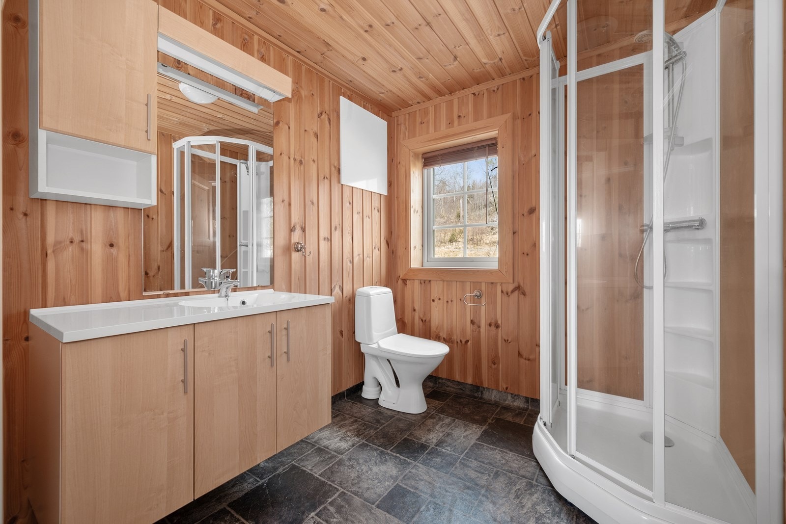 Badet er innredet med toalett, dusjkabinett og god skapplass. Galleribilde