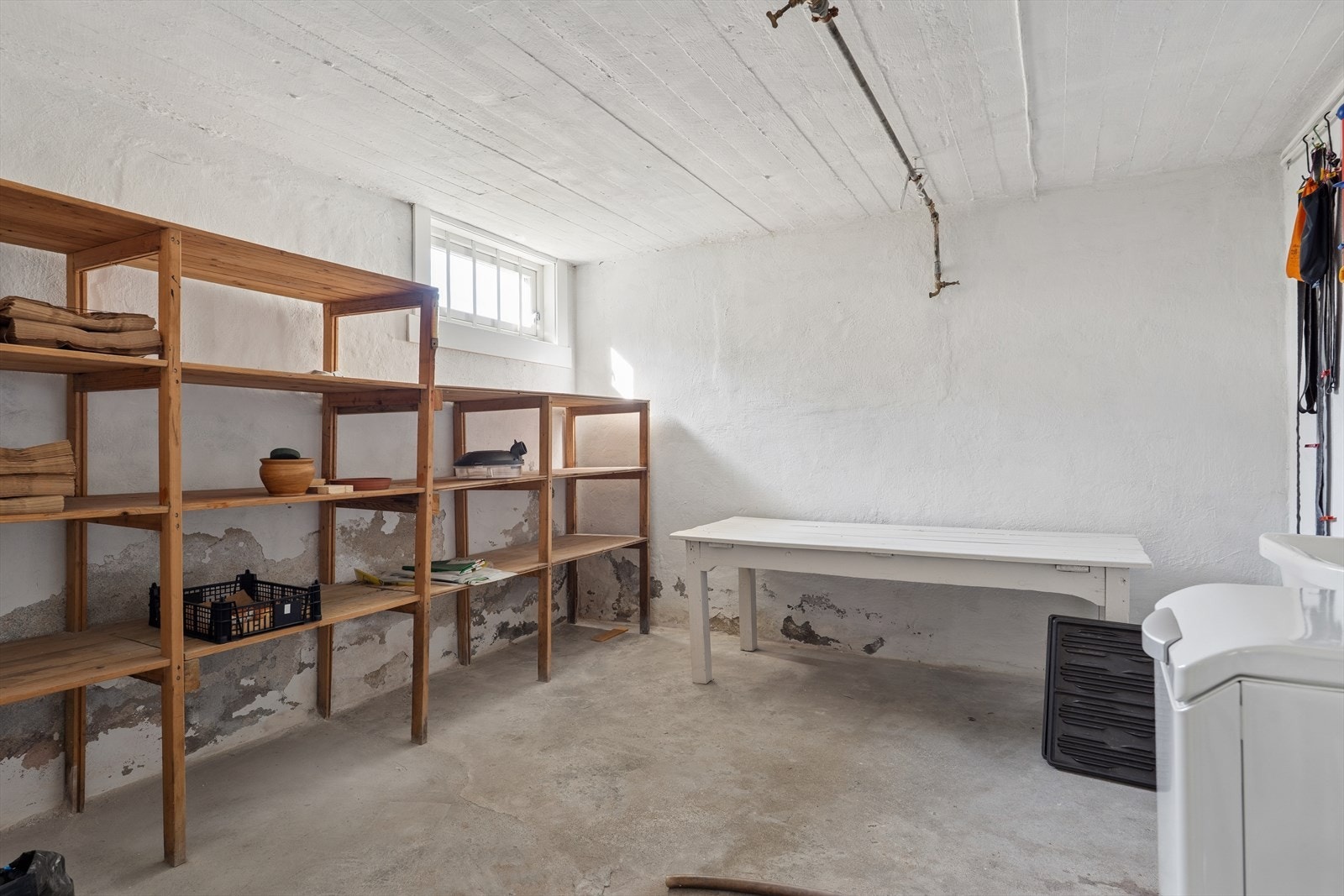Praktisk vaskerom i kjelleren med betonggulv, opplegg for vaskemaskin og utslagskum. Galleribilde
