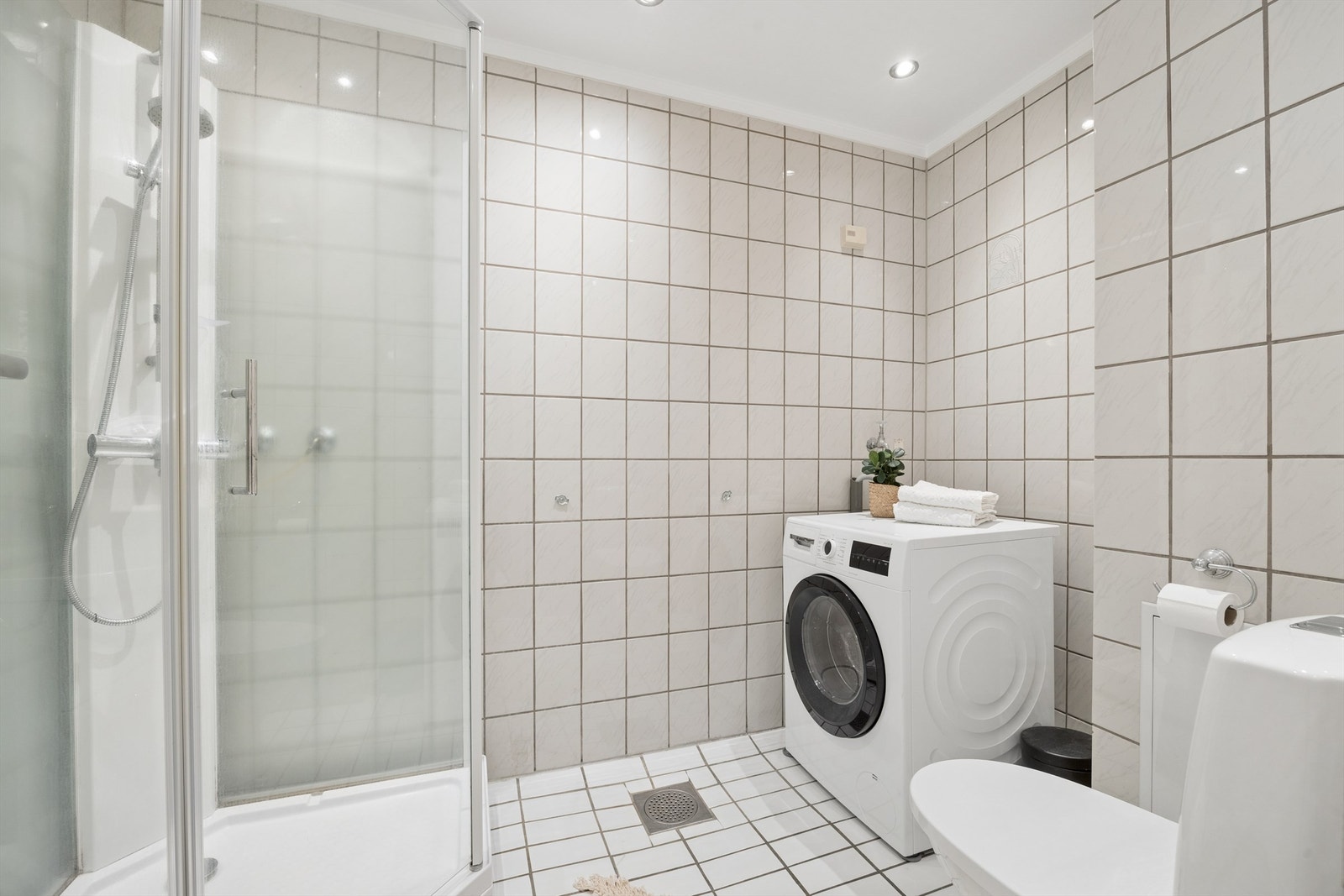 Badet er praktisk innredet med downlights i tak og opplegg for vaskemaskin. Galleribilde