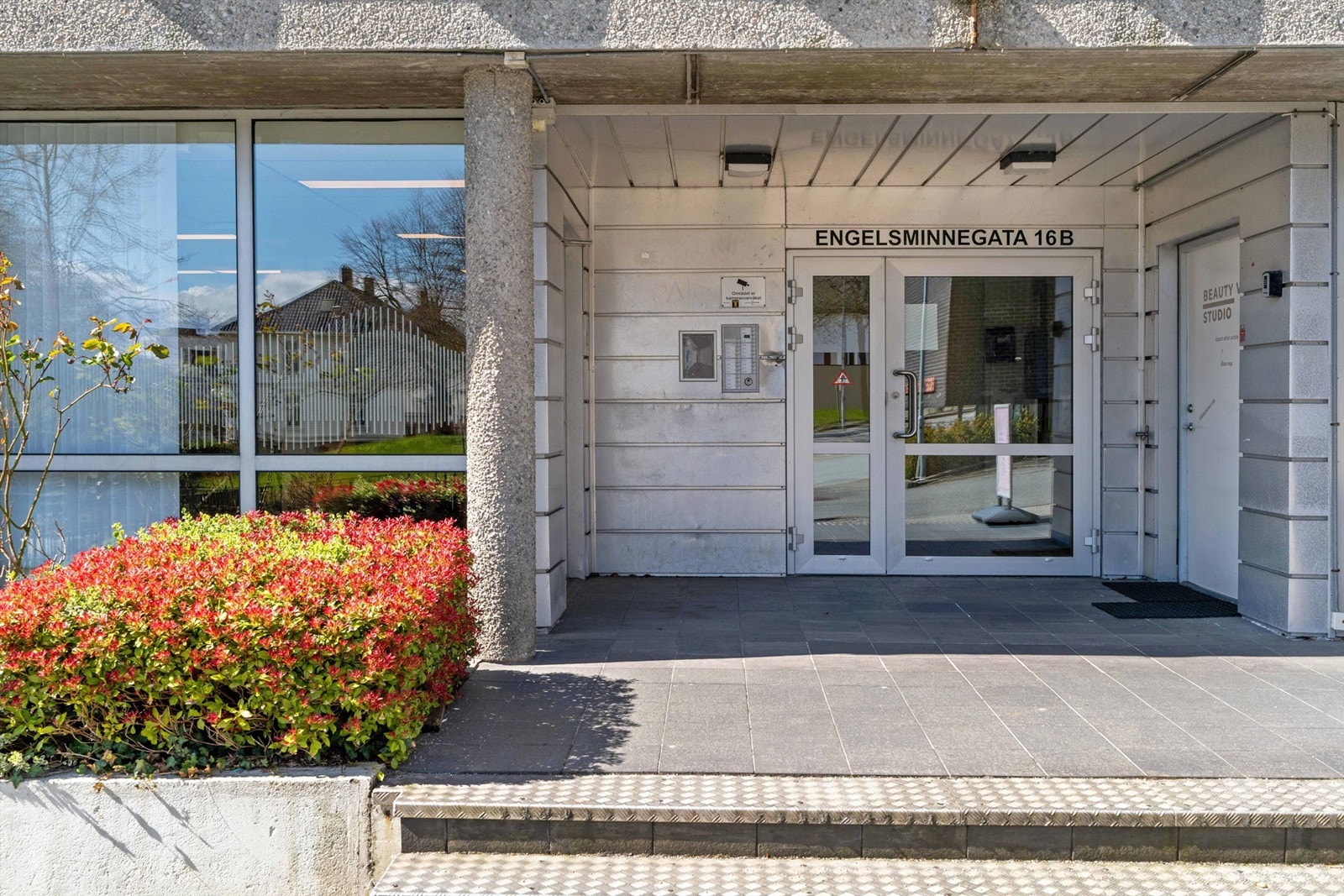 Inngangsparti med ringeklokker for gjester. Postkasser er like innenfor døren. Galleribilde