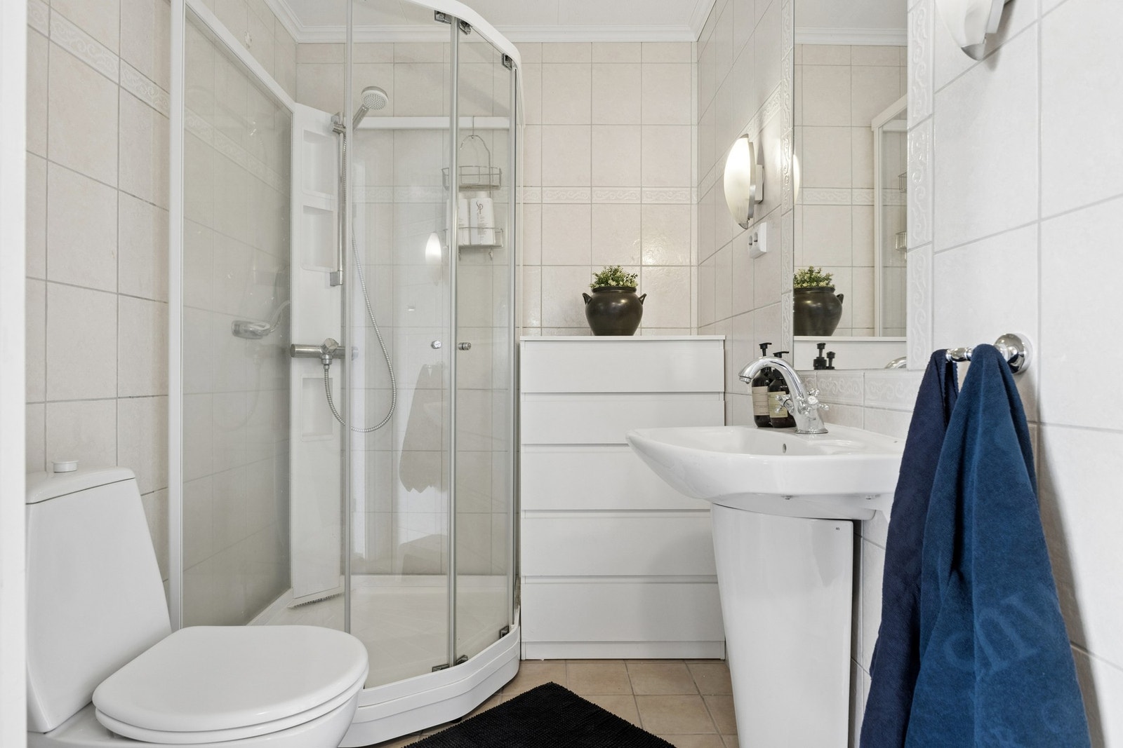 Praktisk bad i hovedetasjen, utstyrt med dusjkabinett, toalett og servant. Galleribilde